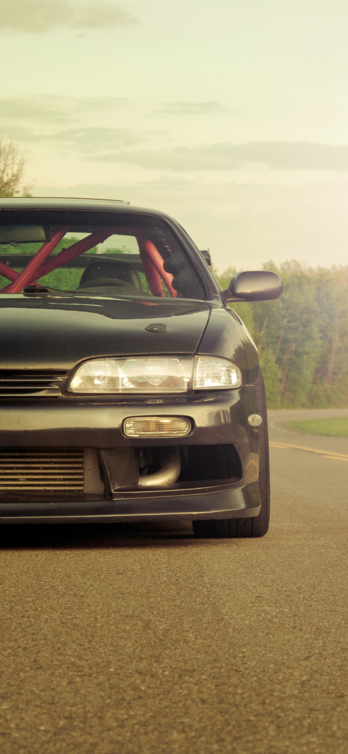 Schwarzer Chevrolet Camaro Tagsüber Unterwegs. Wallpaper in 1125x2436 Resolution