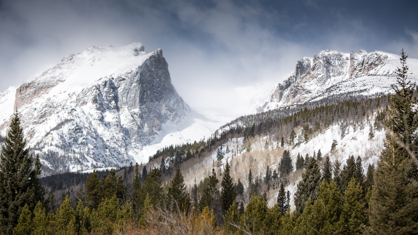 Montagne Couverte de Neige Sous un Ciel Nuageux Pendant la Journée. Wallpaper in 1366x768 Resolution