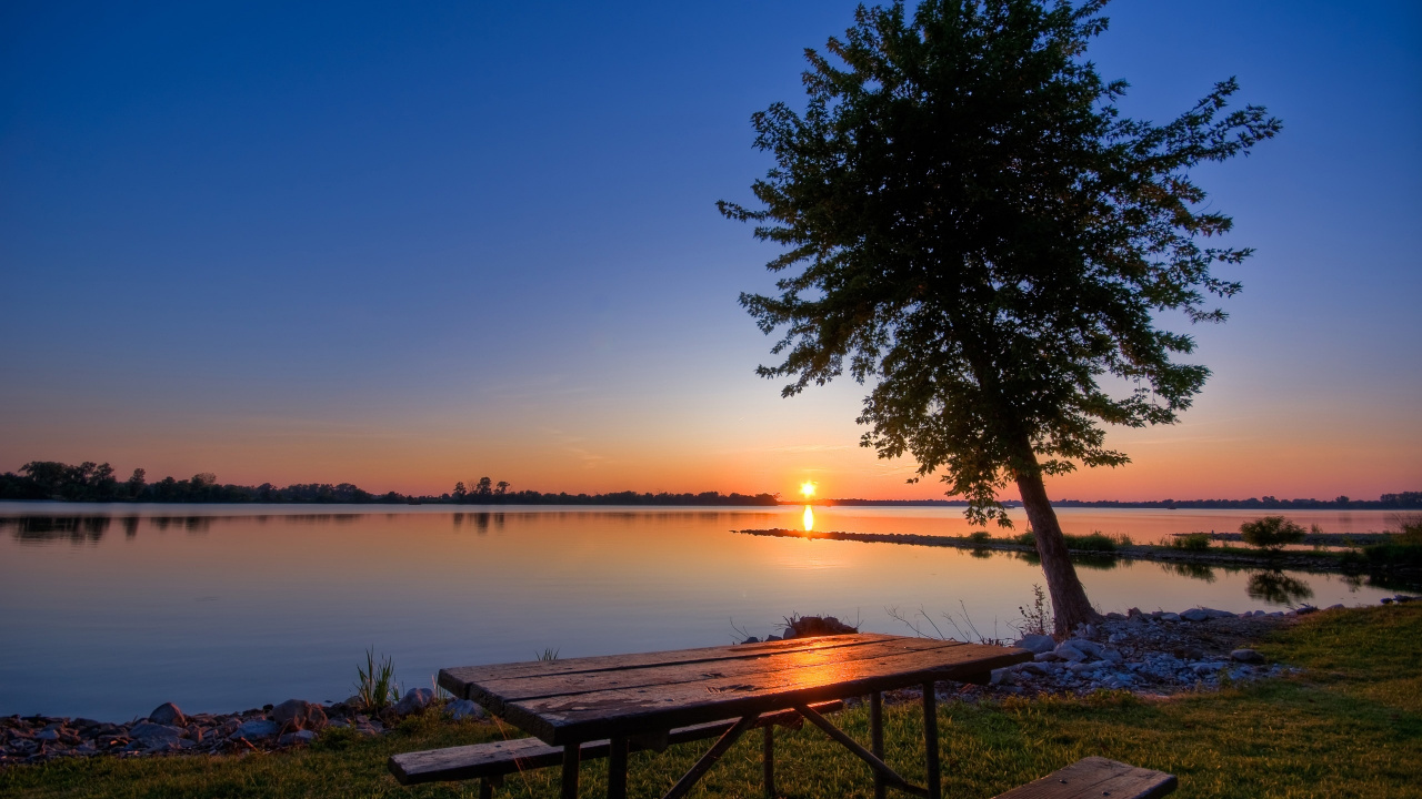 Brown Wooden Bench Near Body of Water During Sunset. Wallpaper in 1280x720 Resolution