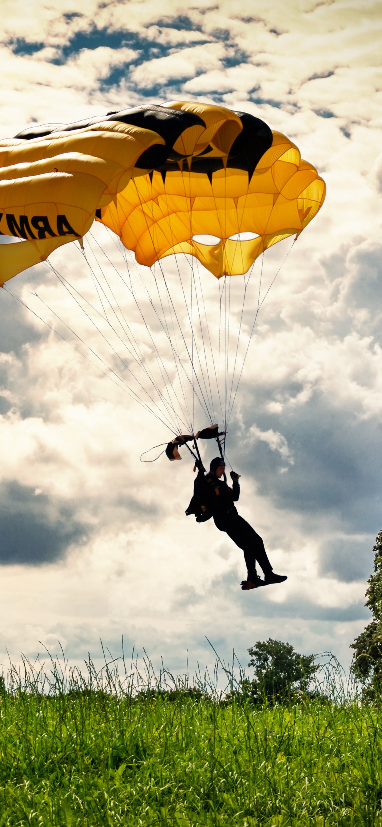 Persona Con Chaqueta y Pantalón Negro Montando en Paracaídas Amarillo Bajo Nubes Blancas Durante el Día. Wallpaper in 1242x2688 Resolution