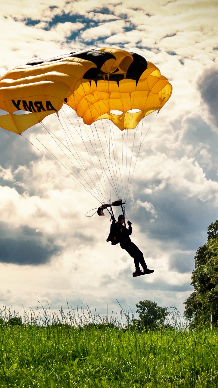 Persona Con Chaqueta y Pantalón Negro Montando en Paracaídas Amarillo Bajo Nubes Blancas Durante el Día. Wallpaper in 720x1280 Resolution