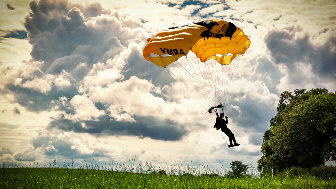 Person in Black Jacket and Pants Riding Yellow Parachute Under White Clouds During Daytime. Wallpaper in 1366x768 Resolution