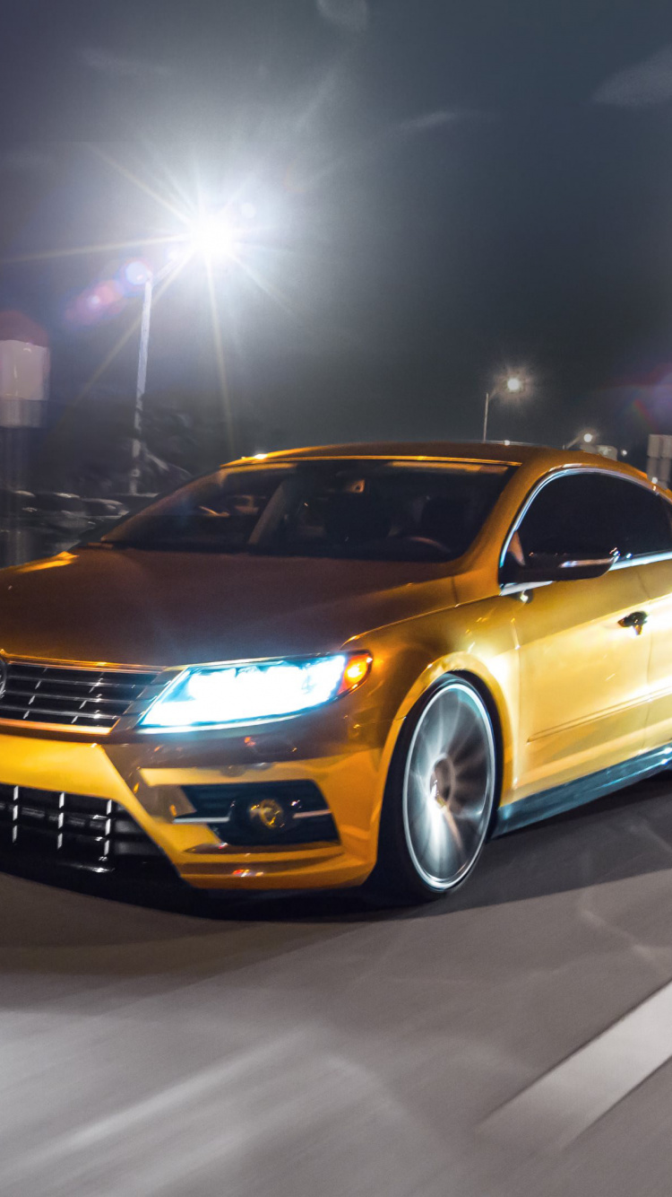 Gelber Chevrolet Camaro Unterwegs Während Der Nacht. Wallpaper in 750x1334 Resolution