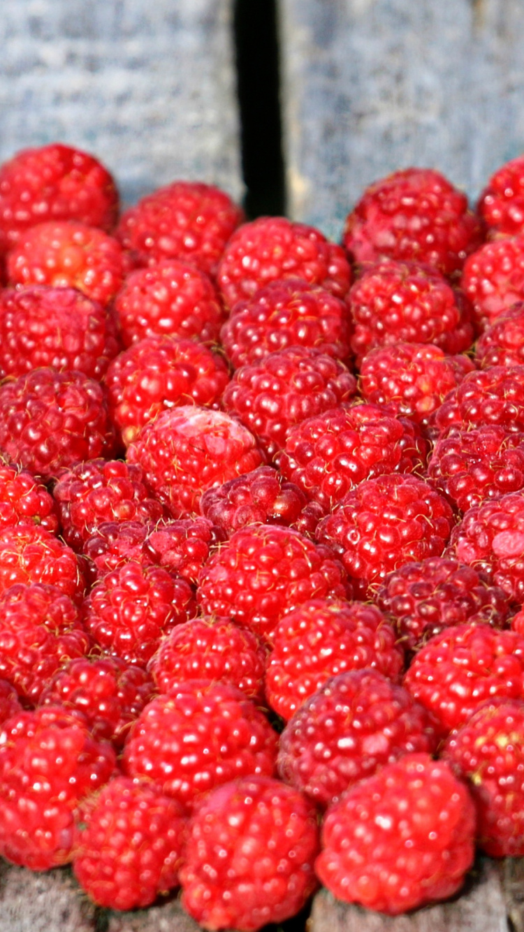 Rote Himbeeren Auf Braunem Holztisch. Wallpaper in 750x1334 Resolution