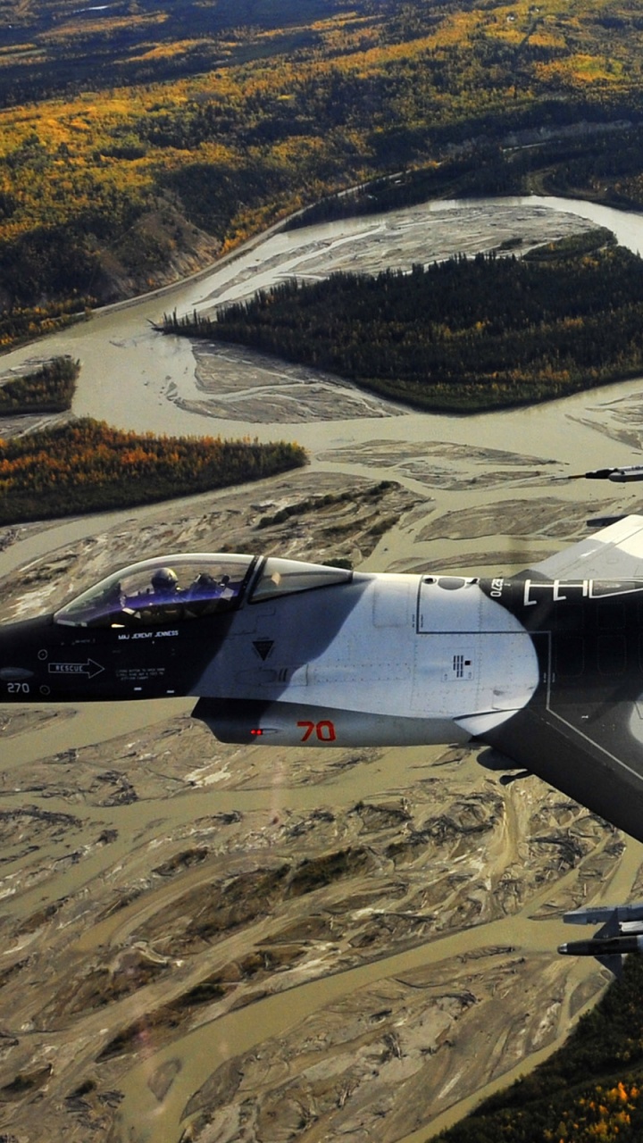 Graues Kampfflugzeug, Das Tagsüber Über Die Berge Fliegt. Wallpaper in 720x1280 Resolution