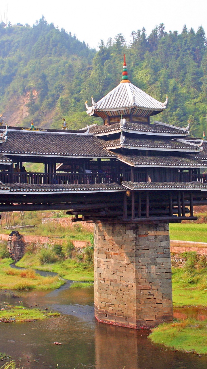 Brown and White Wooden House on Green Grass Field Near Body of Water During Daytime. Wallpaper in 720x1280 Resolution