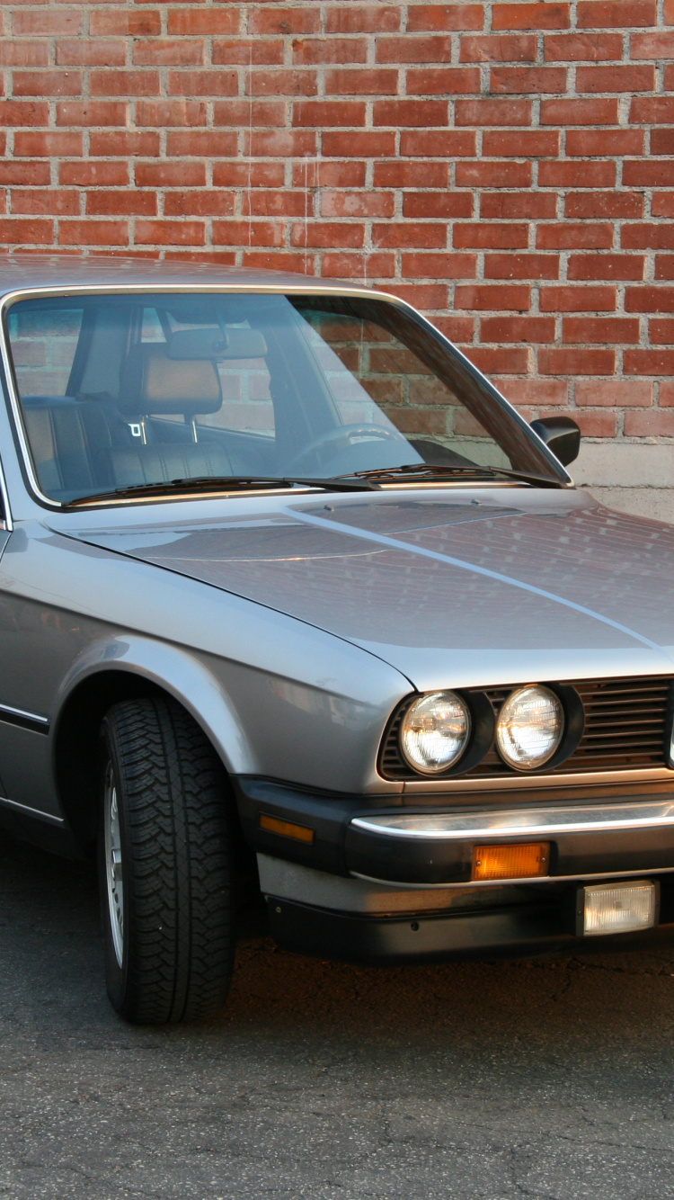 Black Mercedes Benz Coupe Parked Beside Brown Brick Wall. Wallpaper in 750x1334 Resolution