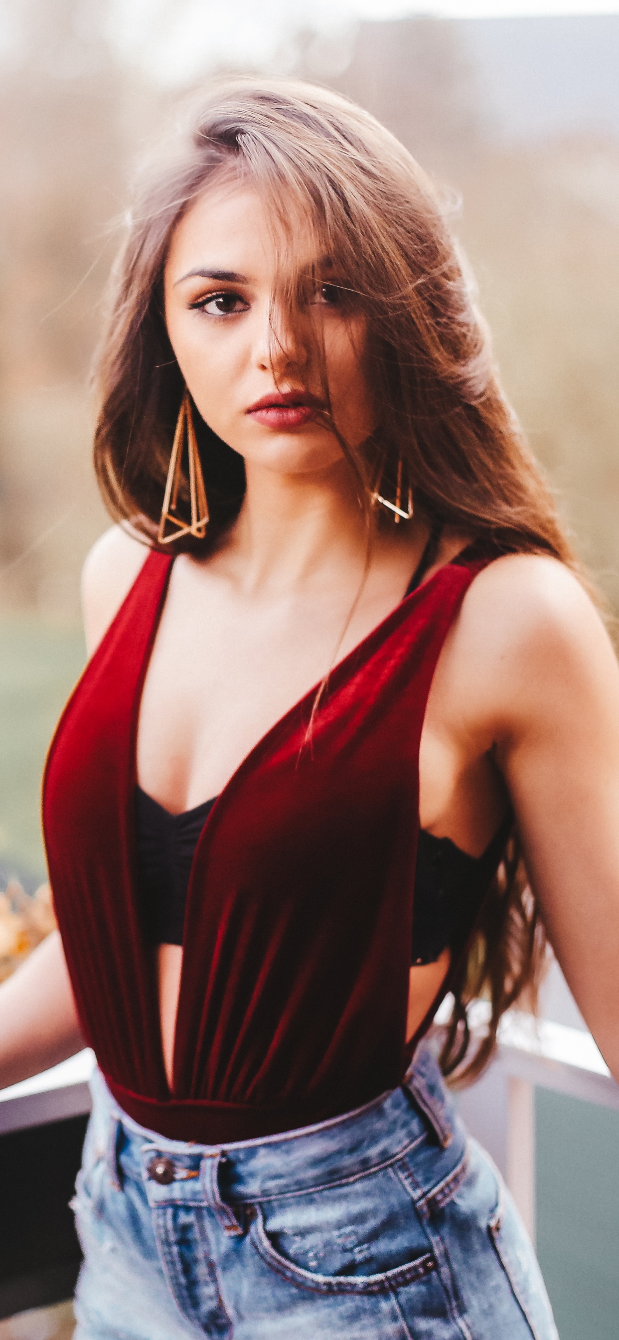 Woman in Red Tank Top and Blue Denim Shorts Standing Beside White Wooden Railings During Daytime. Wallpaper in 1242x2688 Resolution