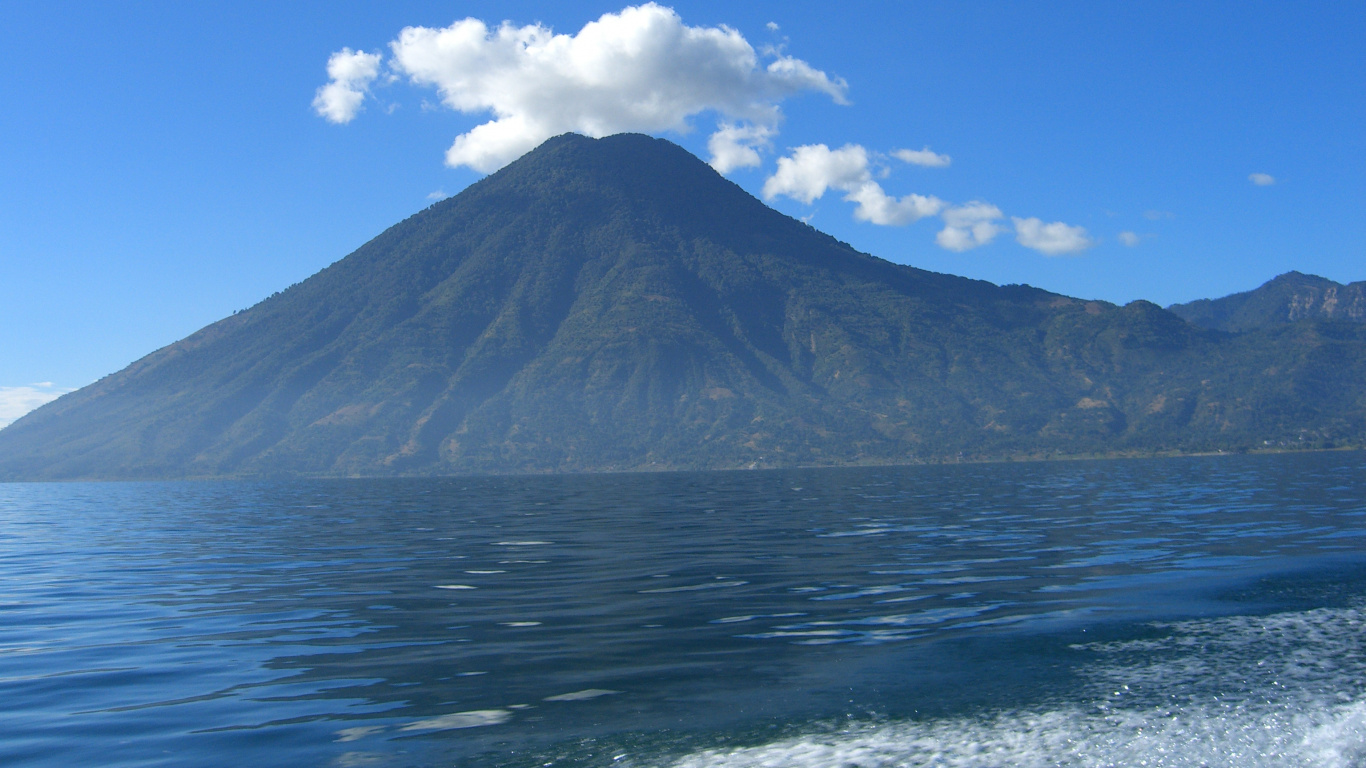 Montaña Cerca Del Cuerpo de Agua Bajo un Cielo Azul Durante el Día. Wallpaper in 1366x768 Resolution