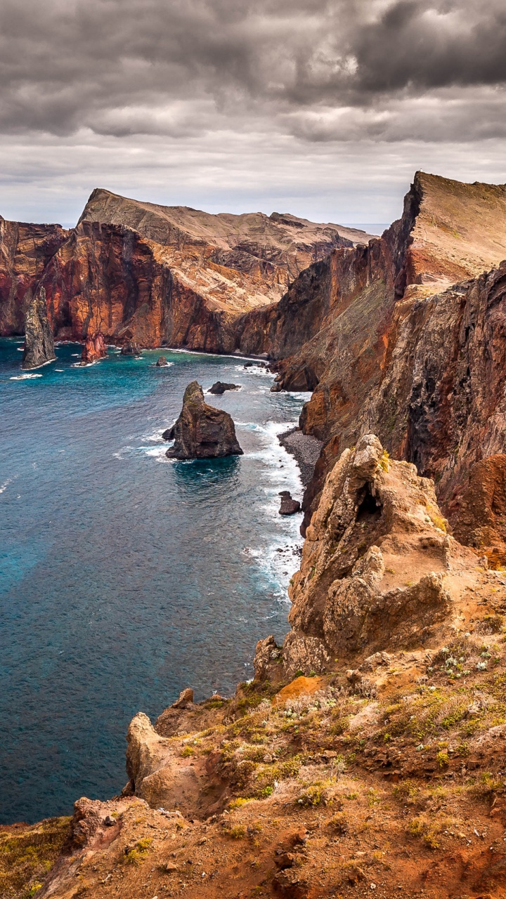 Montagne Rocheuse Brune à Côté de la Mer Bleue Sous le Ciel Bleu Pendant la Journée. Wallpaper in 720x1280 Resolution