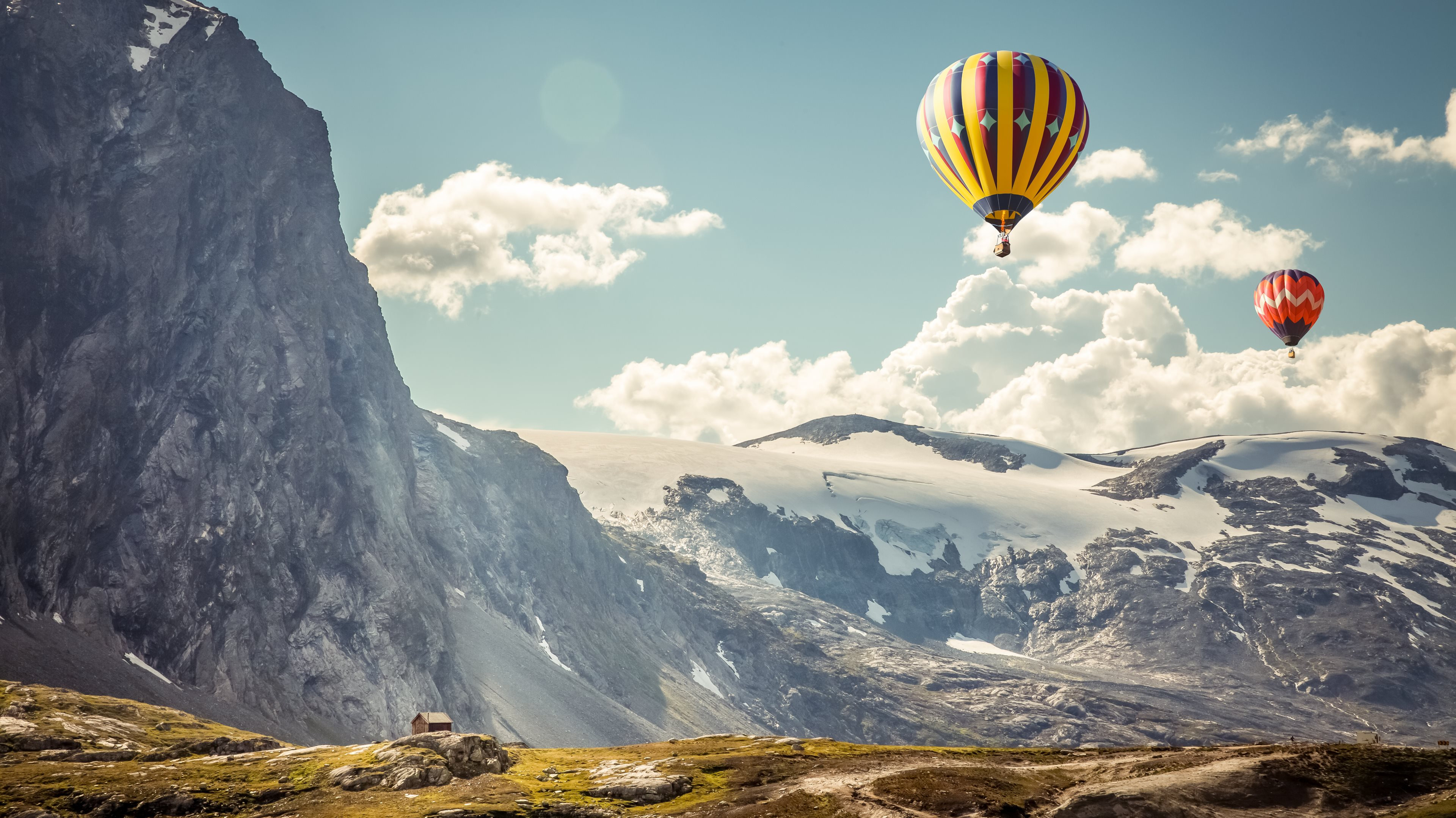Yellow Blue and Red Hot Air Balloon Over Snow Covered Mountain. Wallpaper in 3840x2160 Resolution