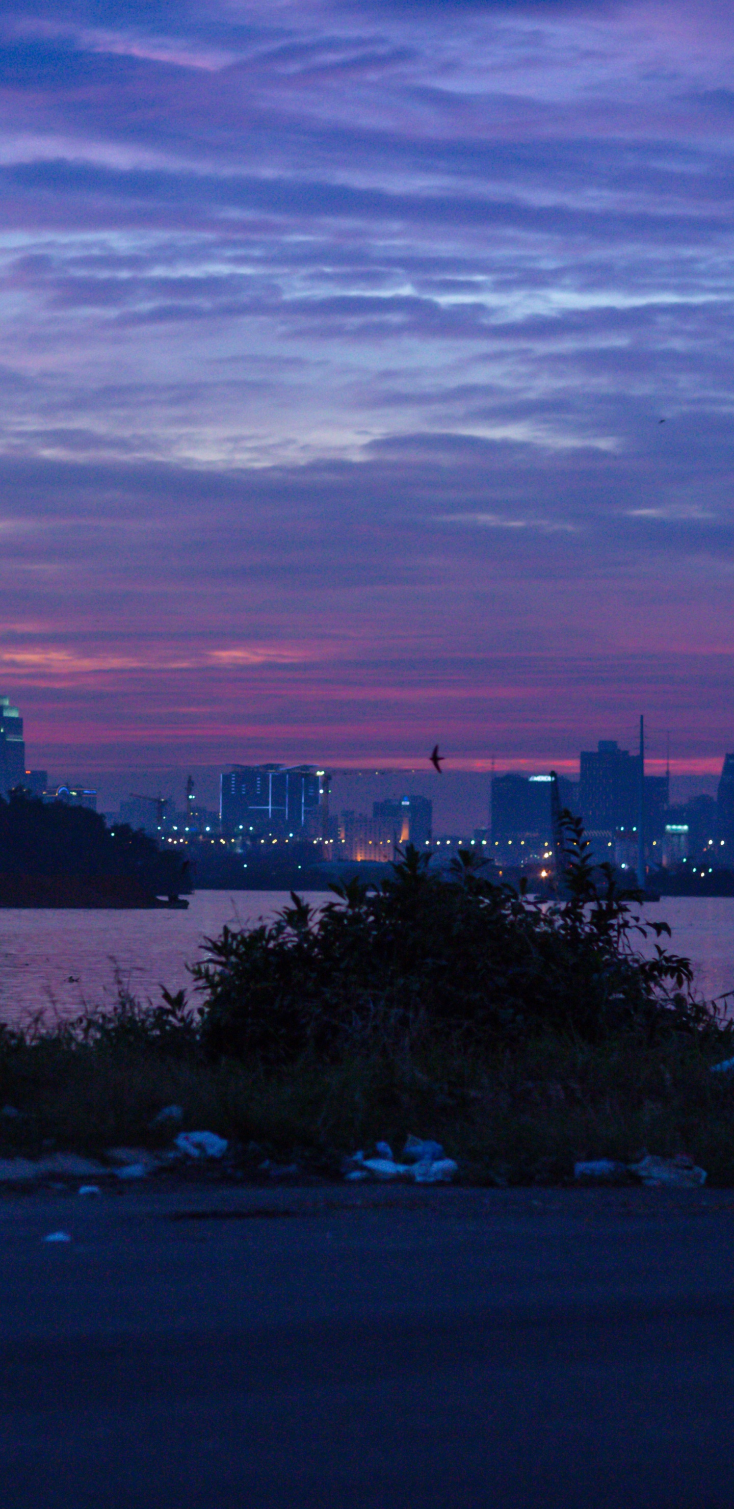 Skyline Der Stadt Unter Bewölktem Himmel Bei Sonnenuntergang. Wallpaper in 1440x2960 Resolution