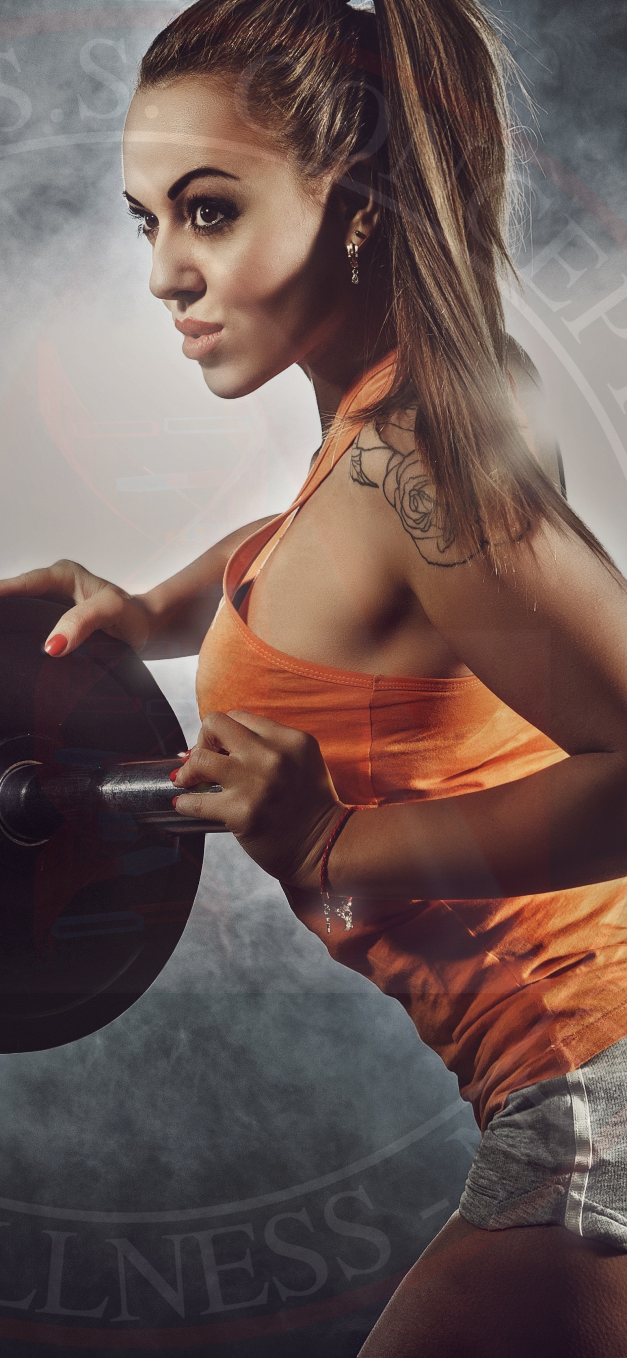 Femme en Débardeur Orange et Short Gris Tenant un Haltère Noir. Wallpaper in 1242x2688 Resolution