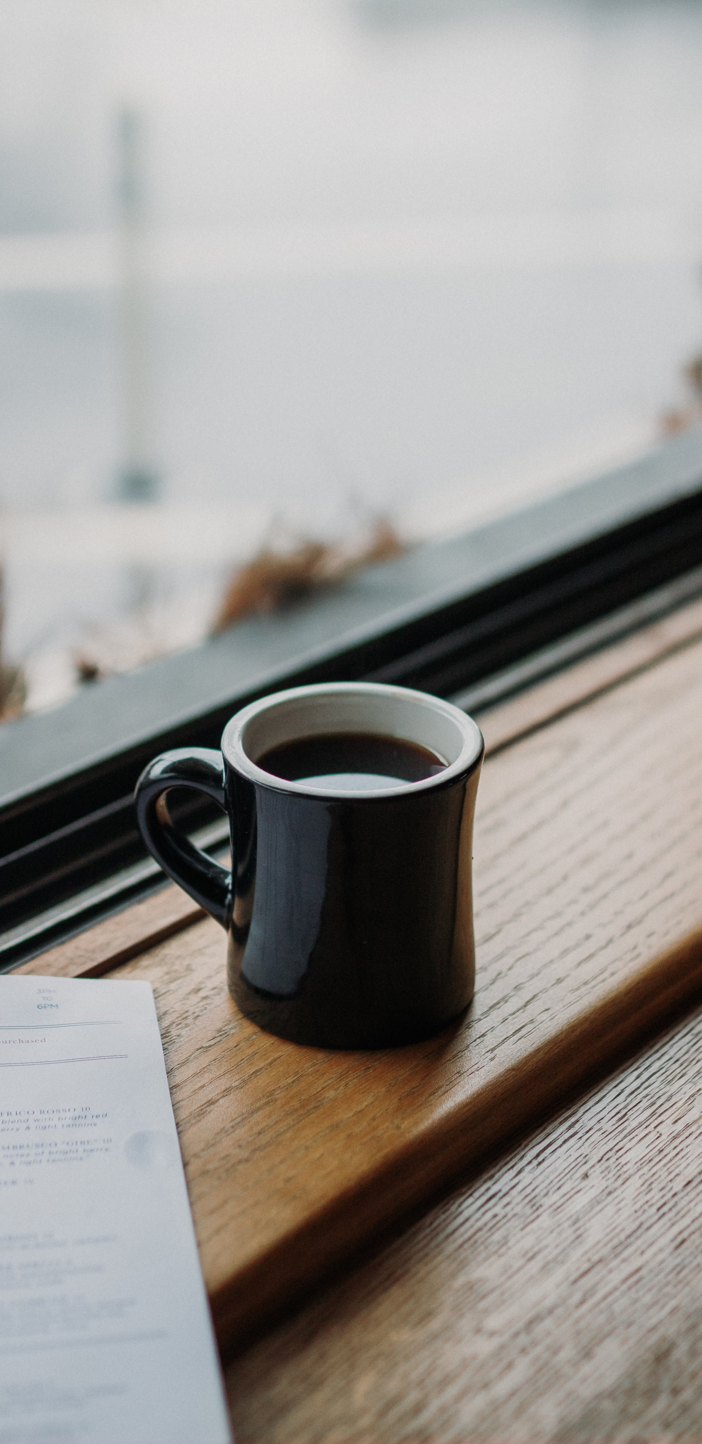 Schwarzer Keramikbecher Auf Braunem Holztisch. Wallpaper in 1440x2960 Resolution