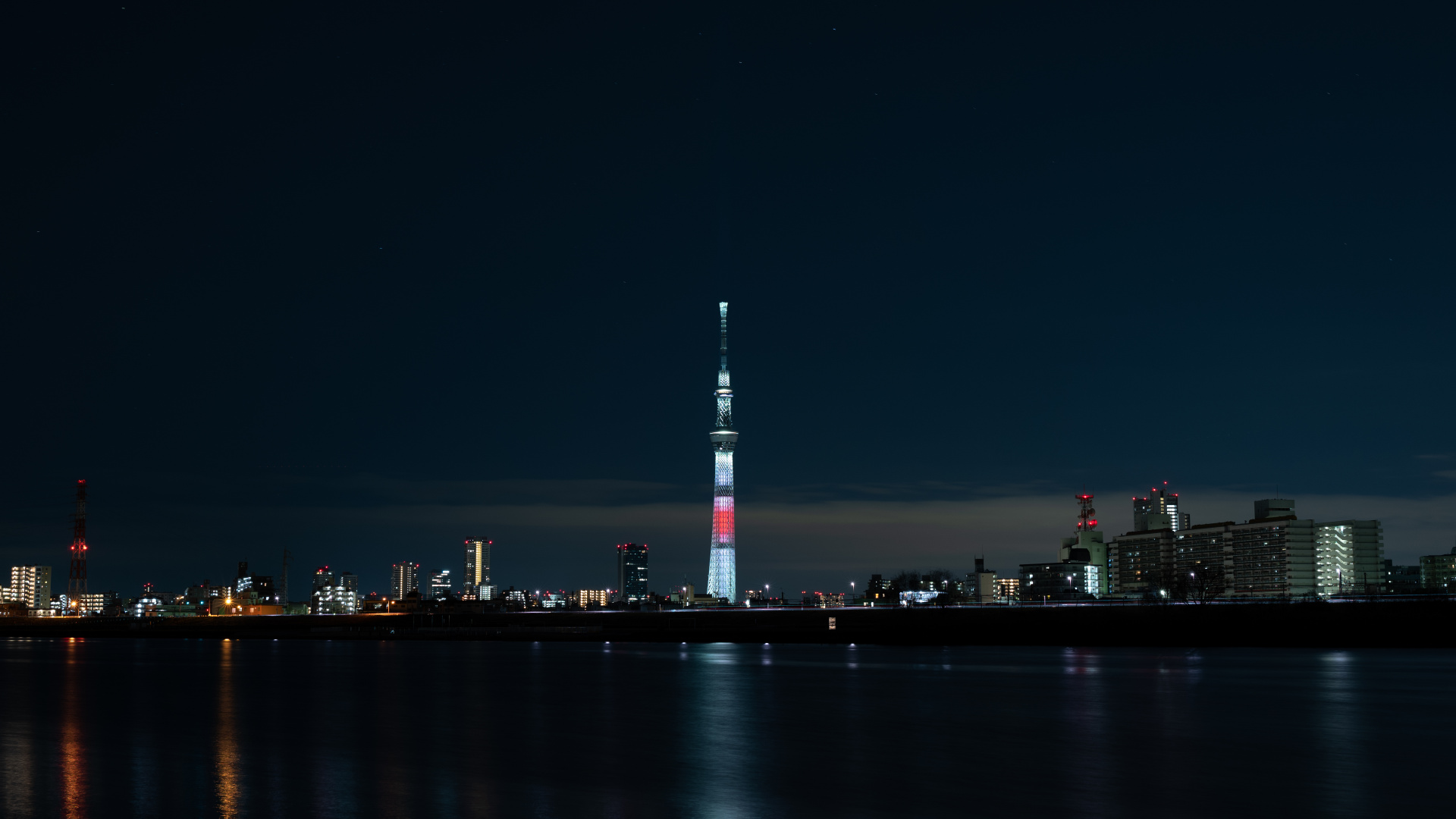 Weißer Und Roter Turm in Der Nähe Eines Gewässers Während Der Nacht. Wallpaper in 1920x1080 Resolution