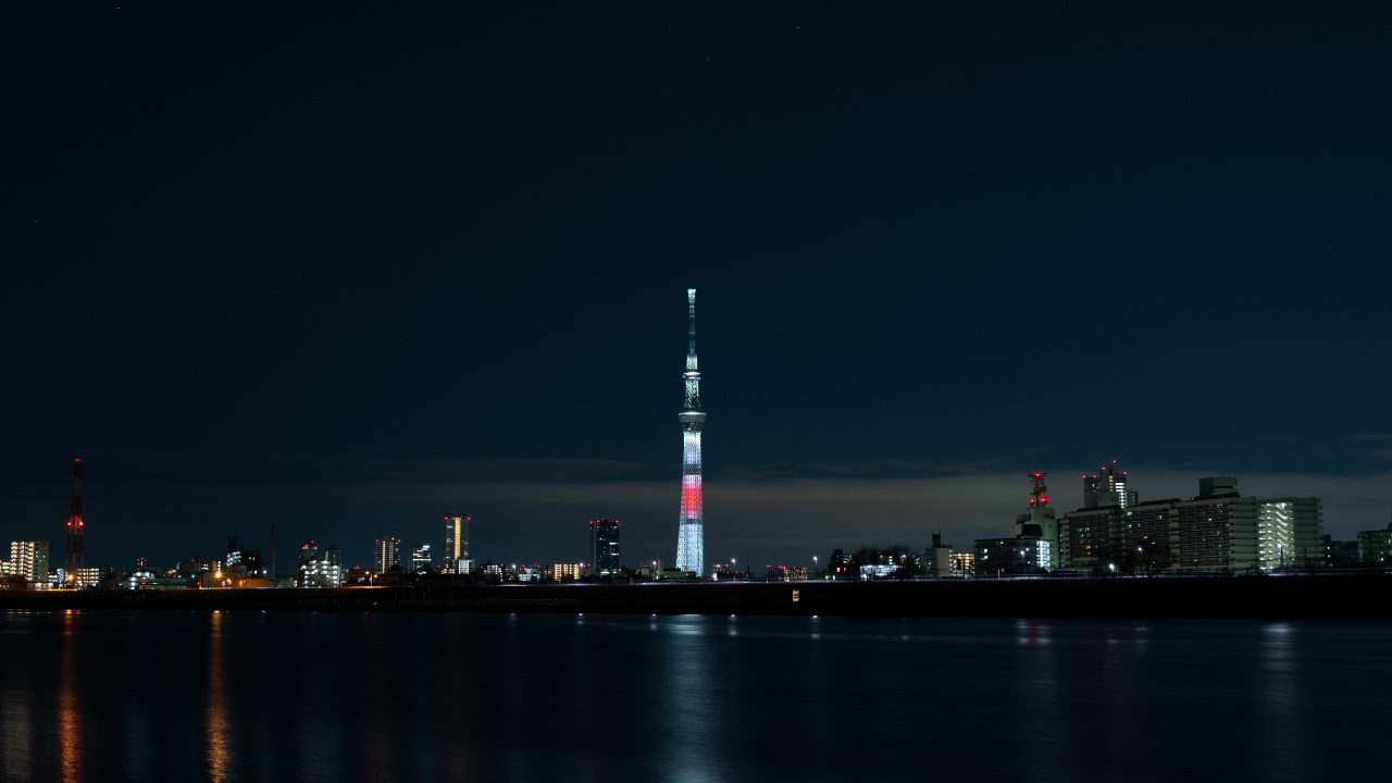 White and Red Tower Near Body of Water During Night Time. Wallpaper in 1280x720 Resolution