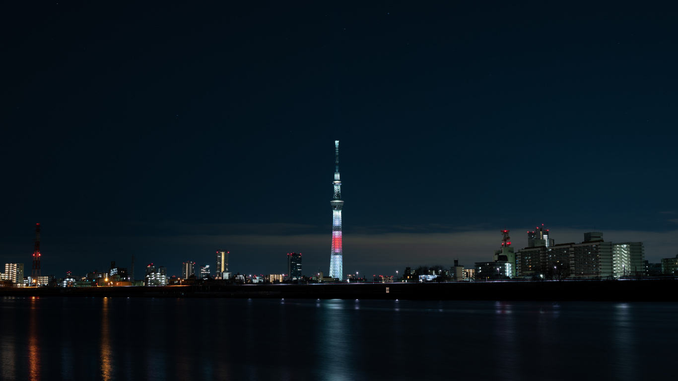 White and Red Tower Near Body of Water During Night Time. Wallpaper in 1366x768 Resolution