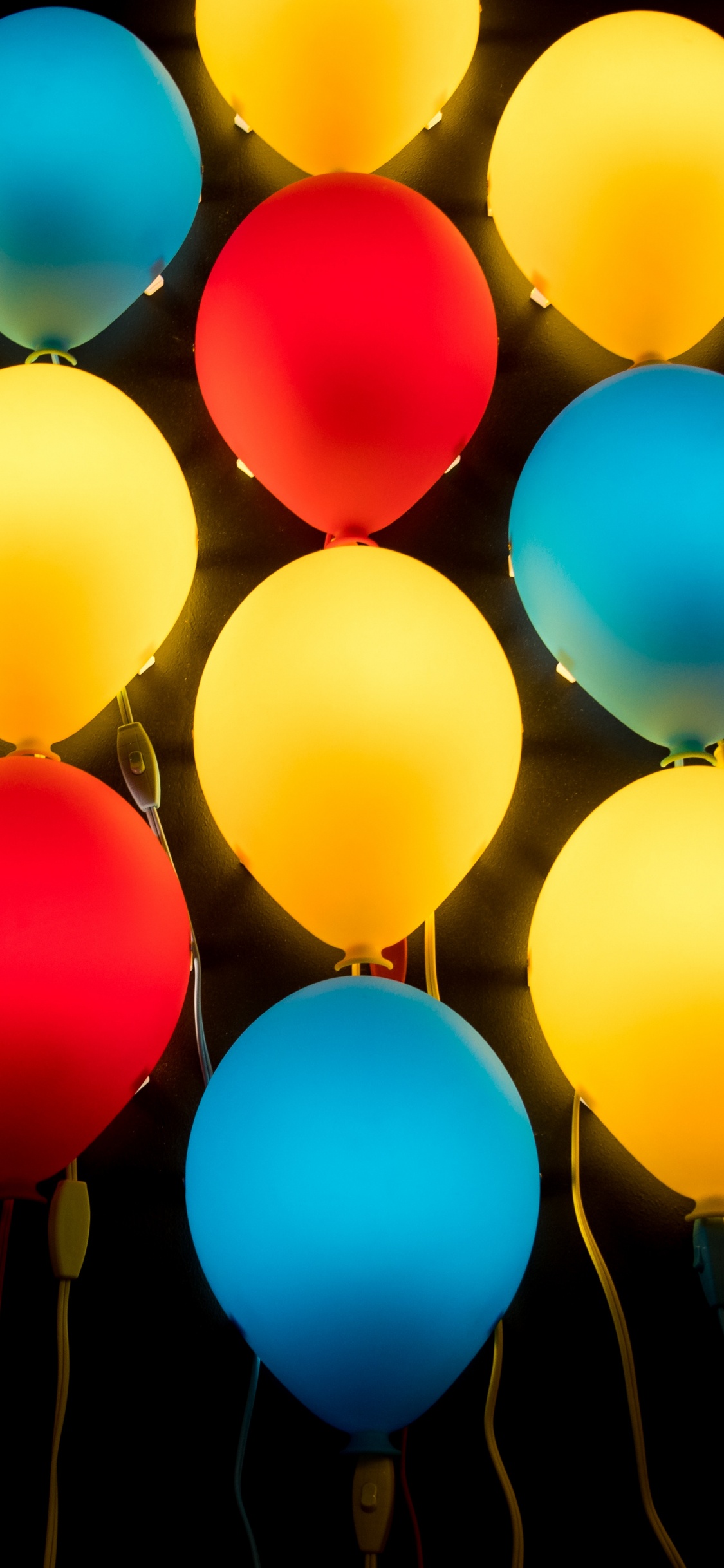 Gelbe Blaue Und Rote Luftballons. Wallpaper in 1125x2436 Resolution