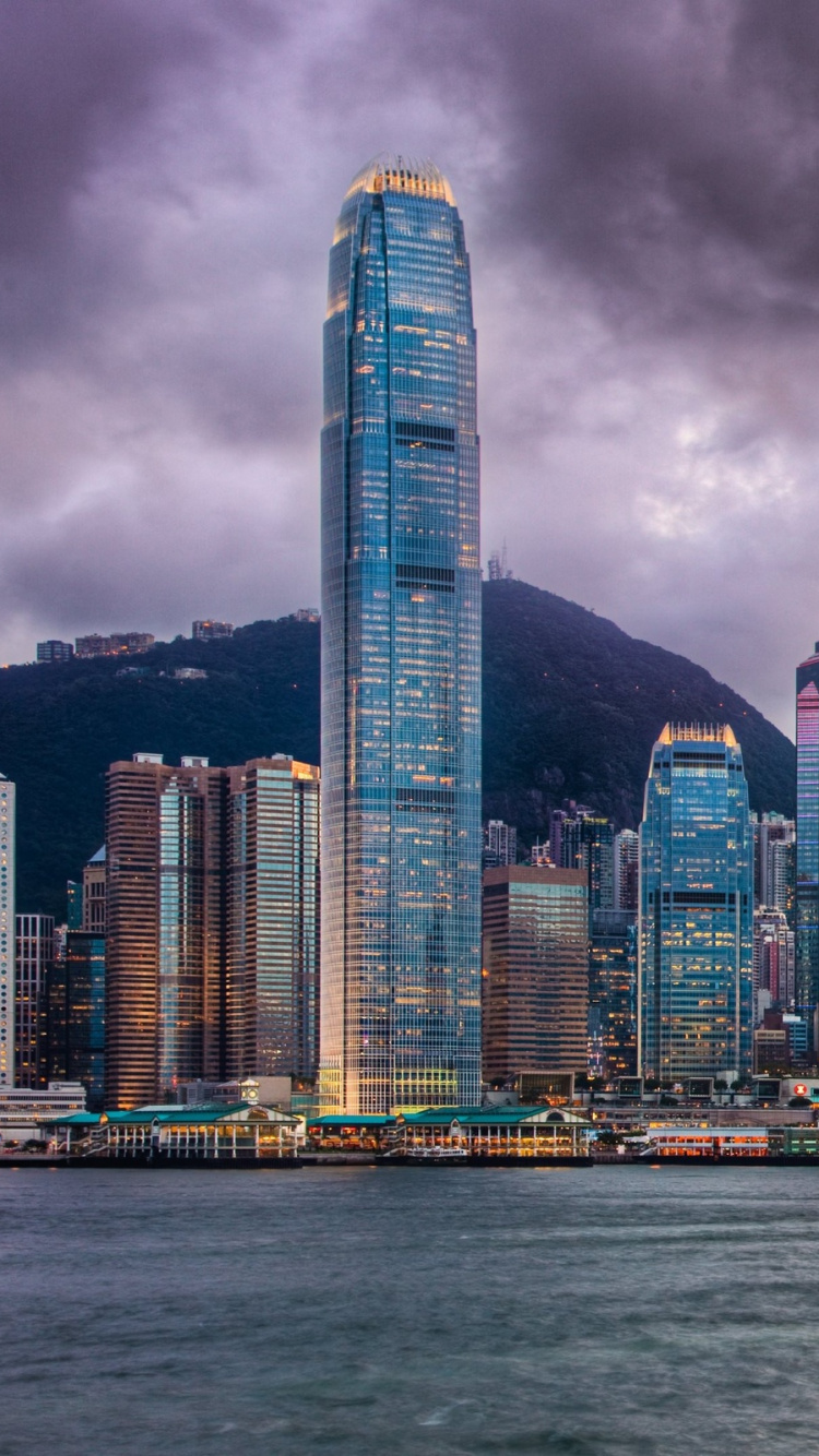 Horizonte de la Ciudad a Través Del Cuerpo de Agua Bajo un Cielo Nublado Durante el Día. Wallpaper in 750x1334 Resolution