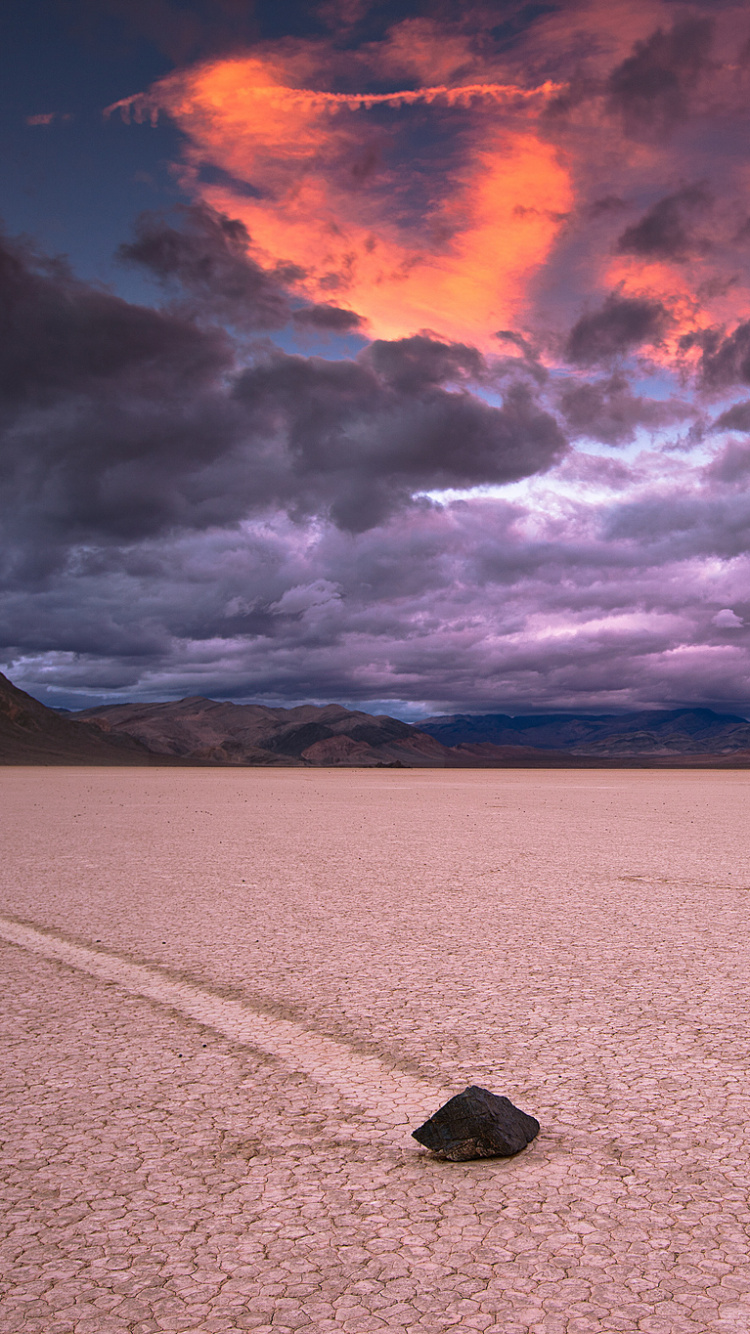 Schwarzer Felsen Auf Weißem Sand in Der Nähe Von Gewässern Tagsüber. Wallpaper in 750x1334 Resolution