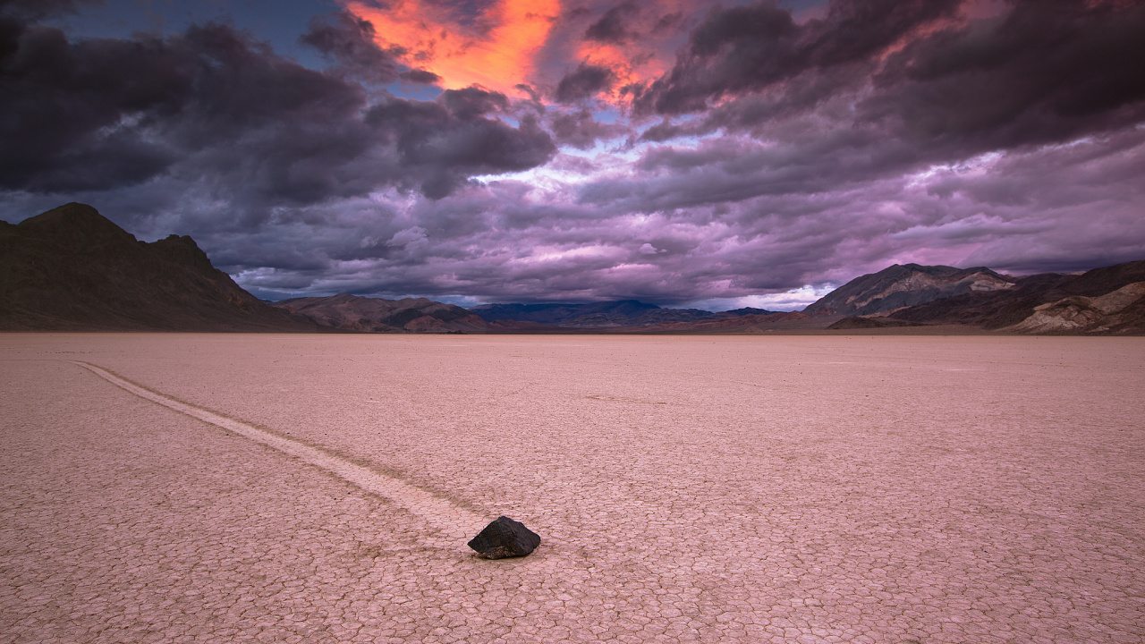 Black Rock on White Sand Near Body of Water During Daytime. Wallpaper in 1280x720 Resolution