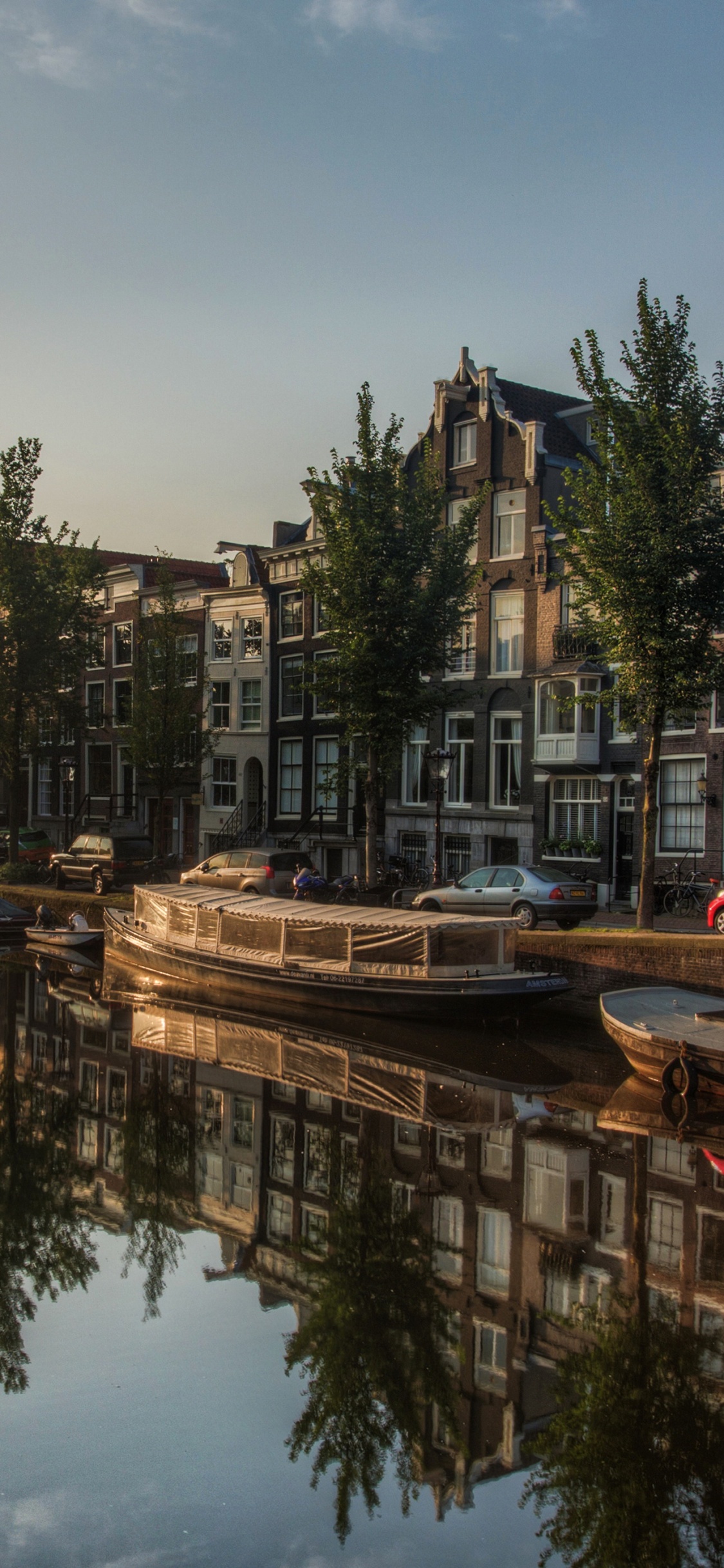 Weißes Und Rotes Boot Auf Dem Wasser in Der Nähe Von Grünen Bäumen Tagsüber. Wallpaper in 1125x2436 Resolution