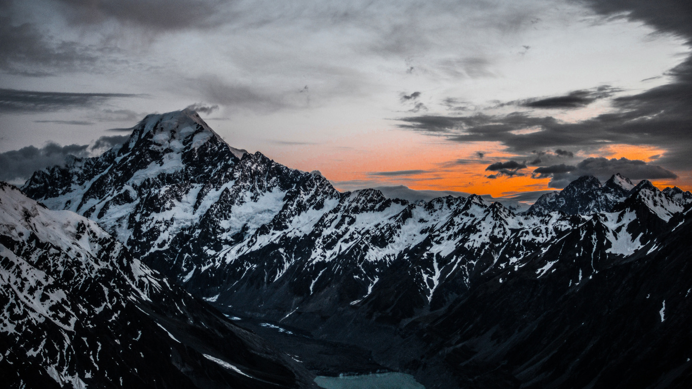 Montagne Couverte de Neige Sous un Ciel Nuageux Pendant la Journée. Wallpaper in 1366x768 Resolution