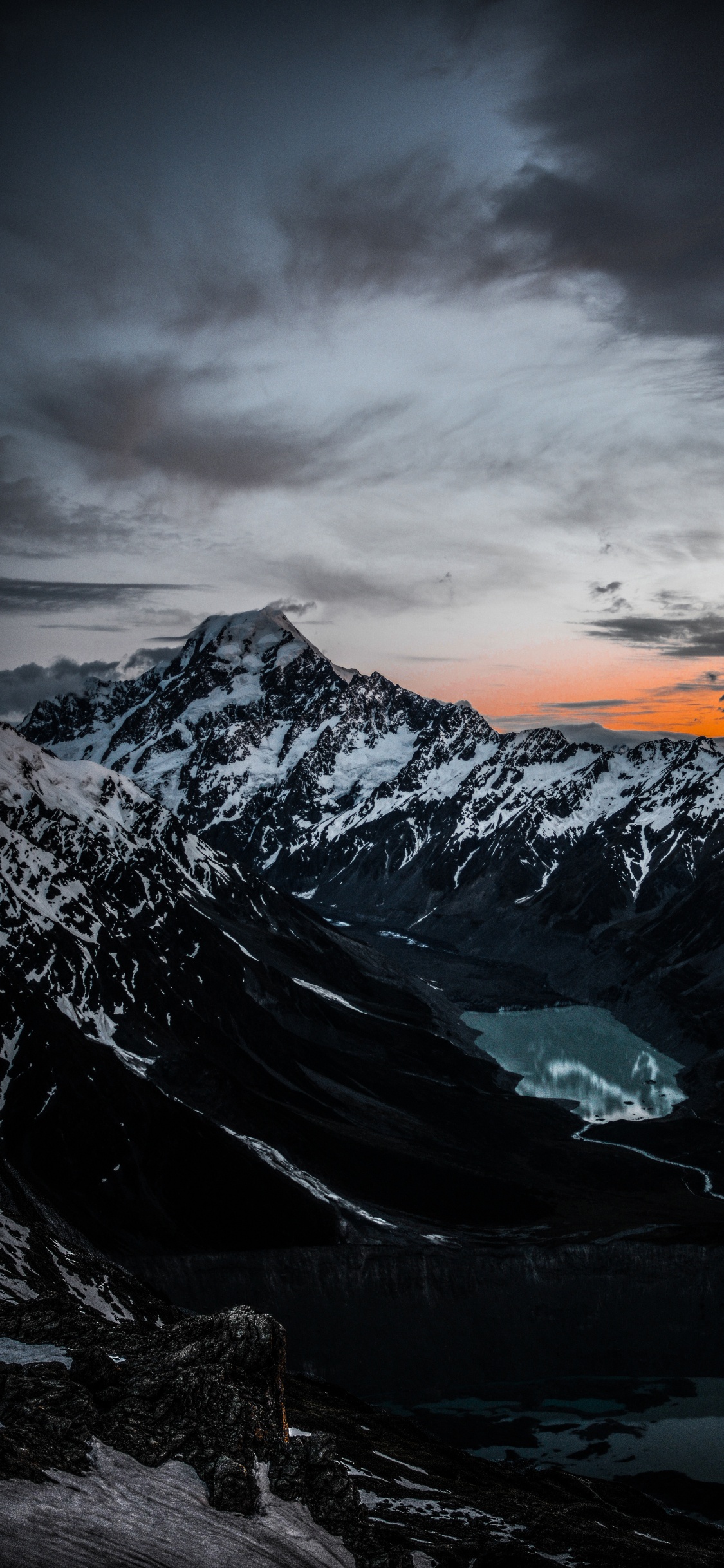 Snow Covered Mountain Under Cloudy Sky During Daytime. Wallpaper in 1125x2436 Resolution