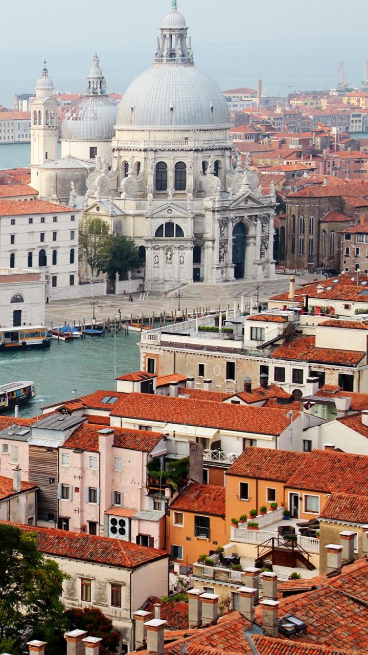 White and Brown Concrete Building Near Body of Water During Daytime. Wallpaper in 720x1280 Resolution