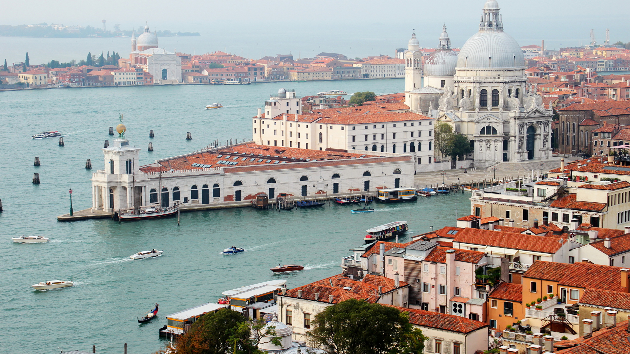 Weißes Und Braunes Betongebäude in Der Nähe Eines Gewässers Tagsüber. Wallpaper in 2560x1440 Resolution