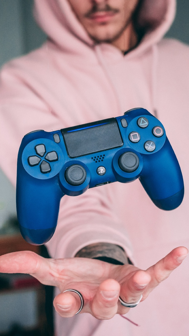 Mann im Weißen Hoodie Mit Blauem Sony PS 4-Controller. Wallpaper in 720x1280 Resolution