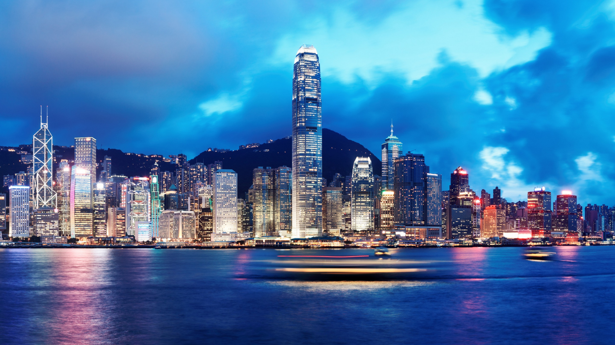 City Skyline Across Body of Water During Night Time. Wallpaper in 2560x1440 Resolution