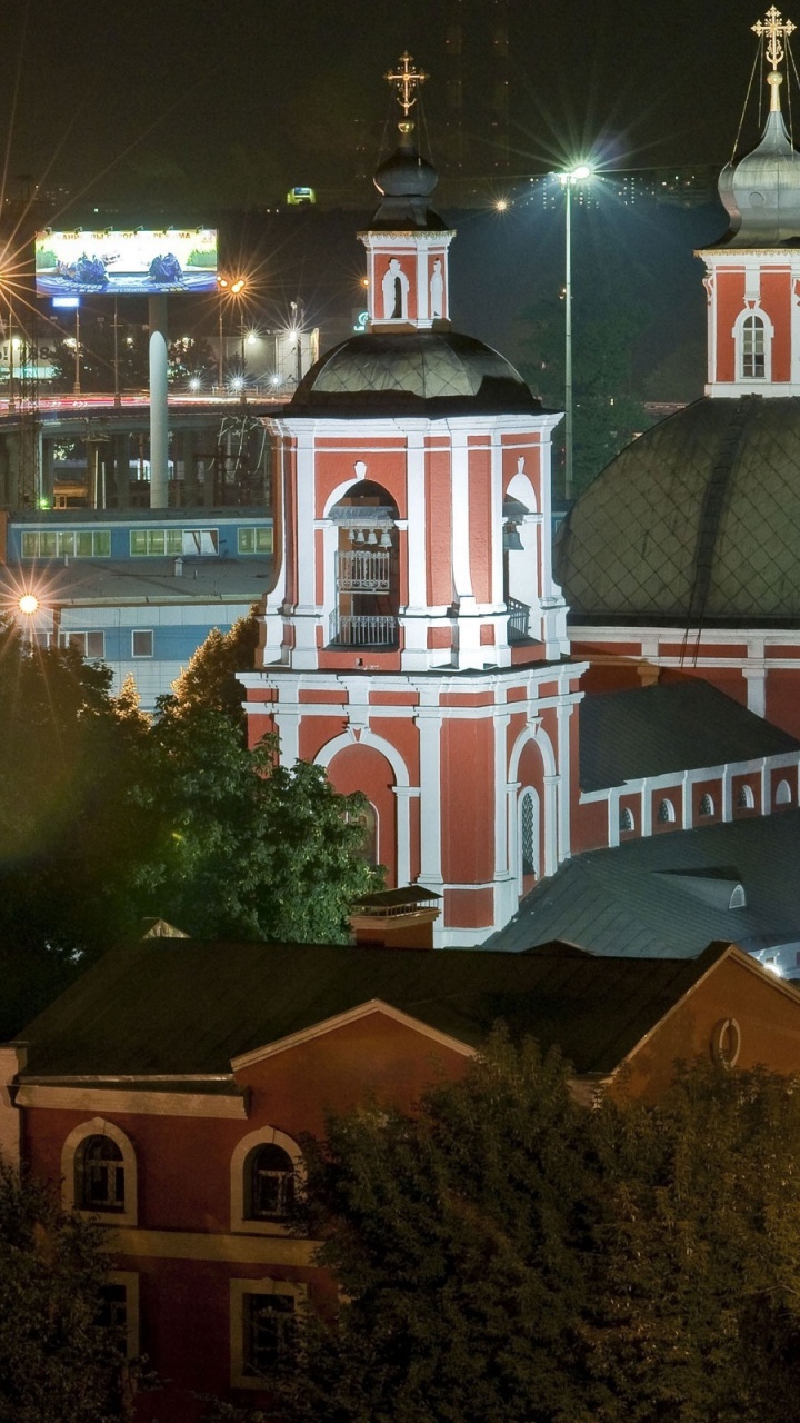 Weißes Und Braunes Betongebäude Während Der Nacht. Wallpaper in 720x1280 Resolution