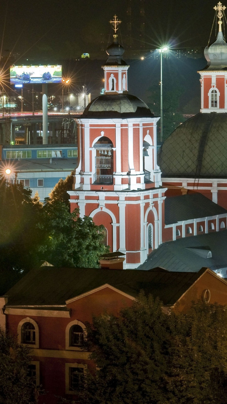 Weißes Und Braunes Betongebäude Während Der Nacht. Wallpaper in 750x1334 Resolution