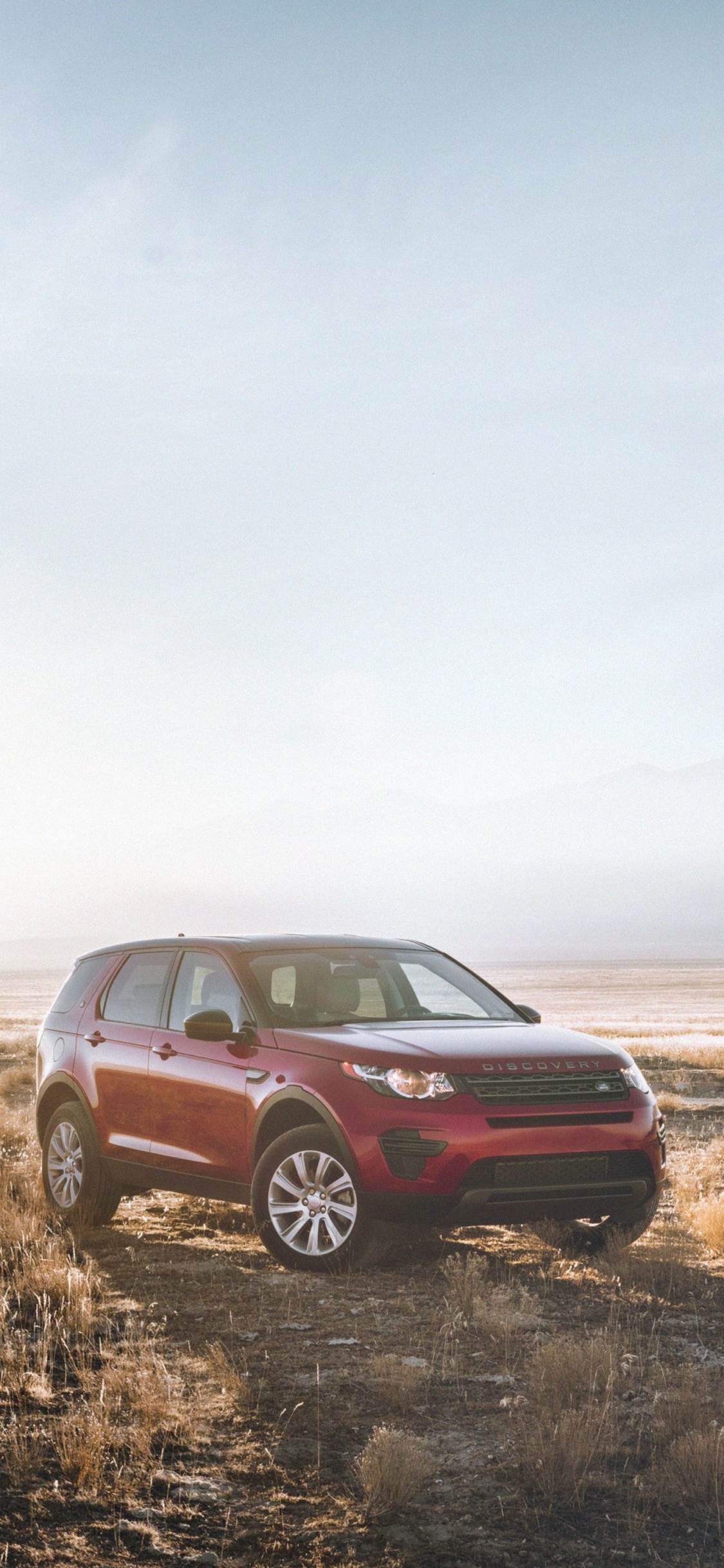 Red Suv on Brown Grass Field Under White Sky During Daytime. Wallpaper in 1125x2436 Resolution