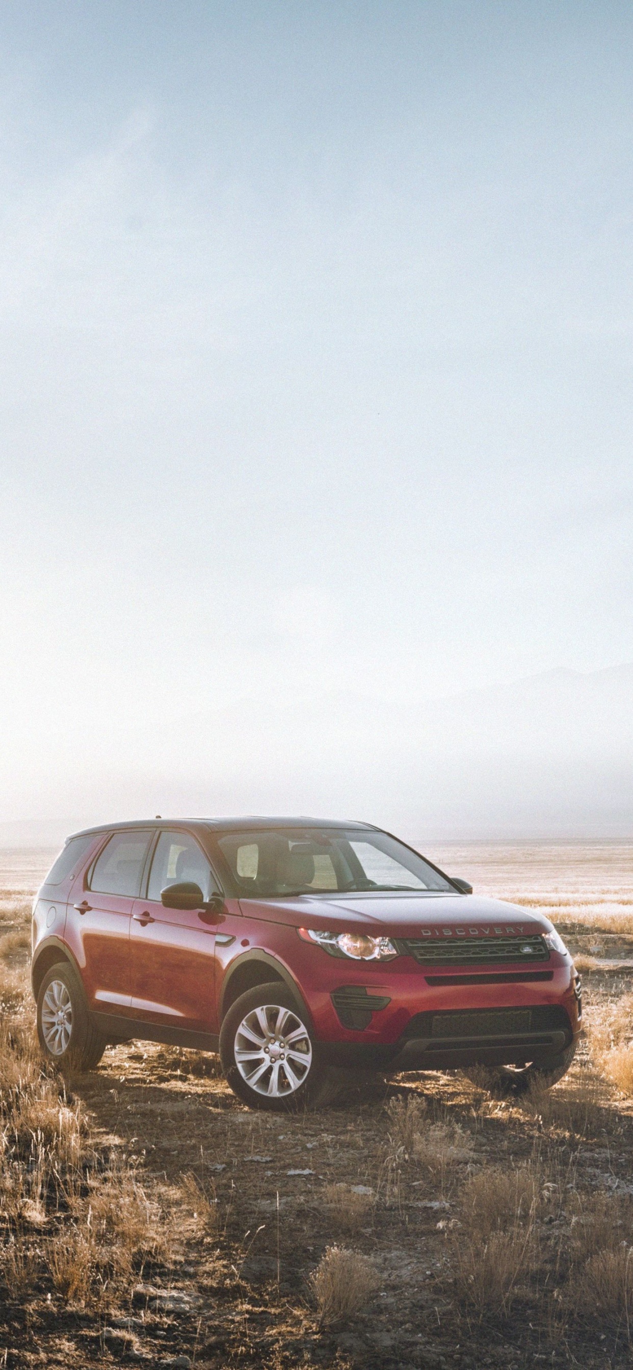 Red Suv on Brown Grass Field Under White Sky During Daytime. Wallpaper in 1242x2688 Resolution