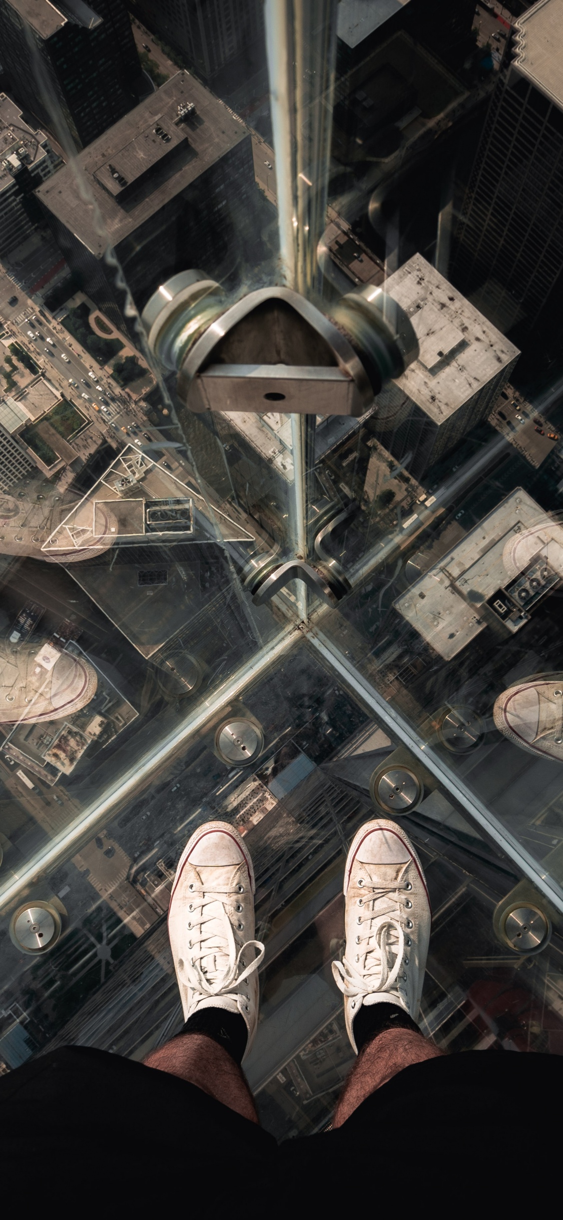 Person in Black Pants and White Sneakers Standing on Glass Top Table. Wallpaper in 1125x2436 Resolution