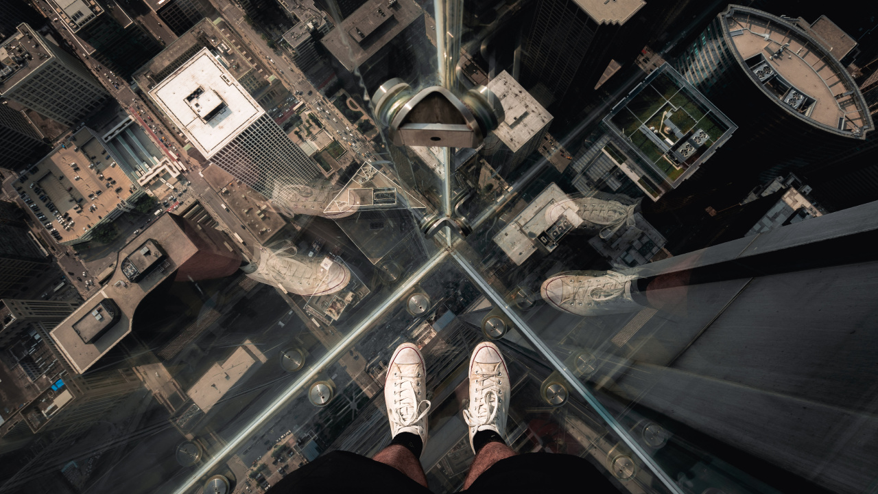 Person in Black Pants and White Sneakers Standing on Glass Top Table. Wallpaper in 1280x720 Resolution