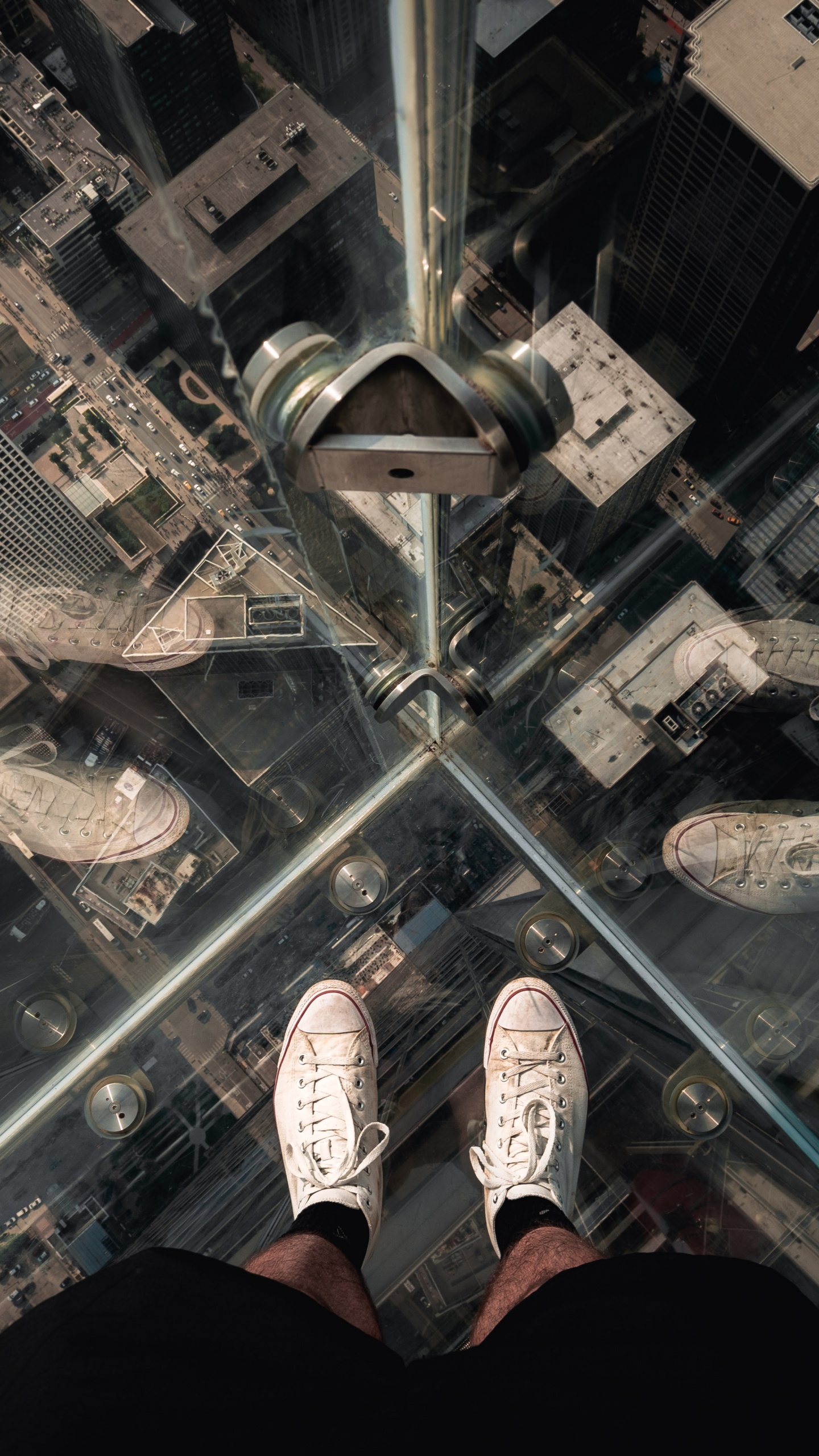 Person in Black Pants and White Sneakers Standing on Glass Top Table. Wallpaper in 1440x2560 Resolution