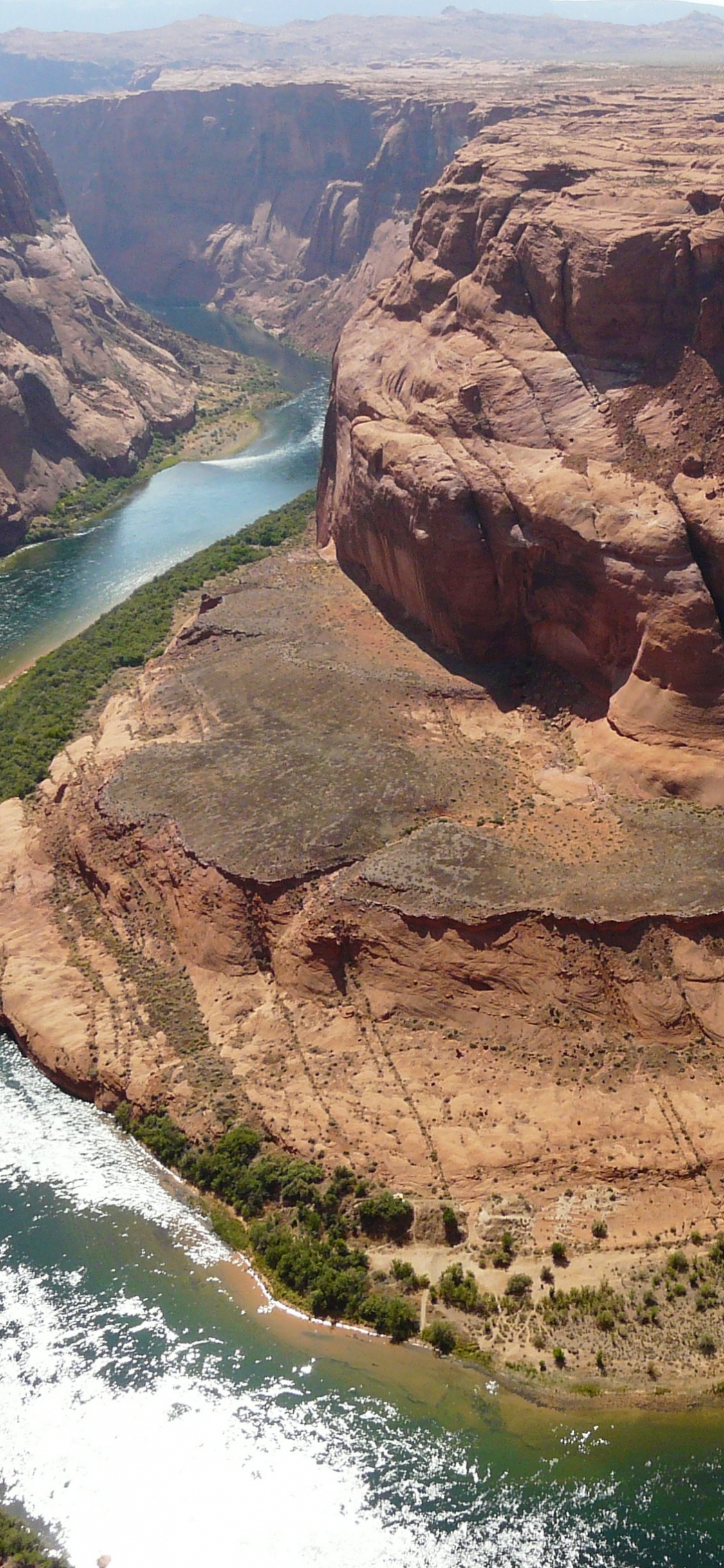Brown Rock Formation Near Body of Water During Daytime. Wallpaper in 1125x2436 Resolution