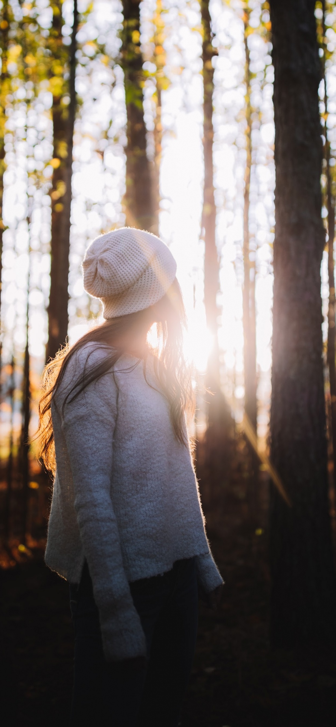 Frau in Weißer Strickmütze Und Grauem Pullover im Wald Tagsüber. Wallpaper in 1125x2436 Resolution