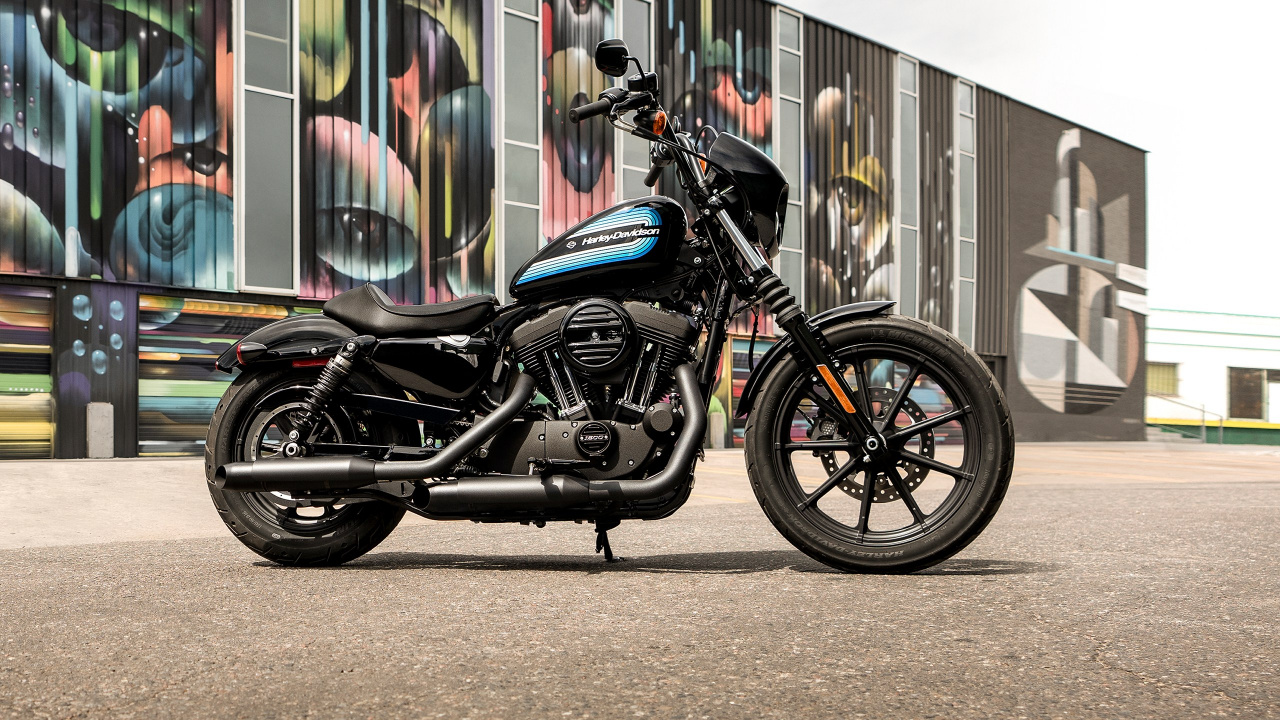 Schwarz-blaues Nacktes Motorrad Neben Der Wand Geparkt. Wallpaper in 1280x720 Resolution