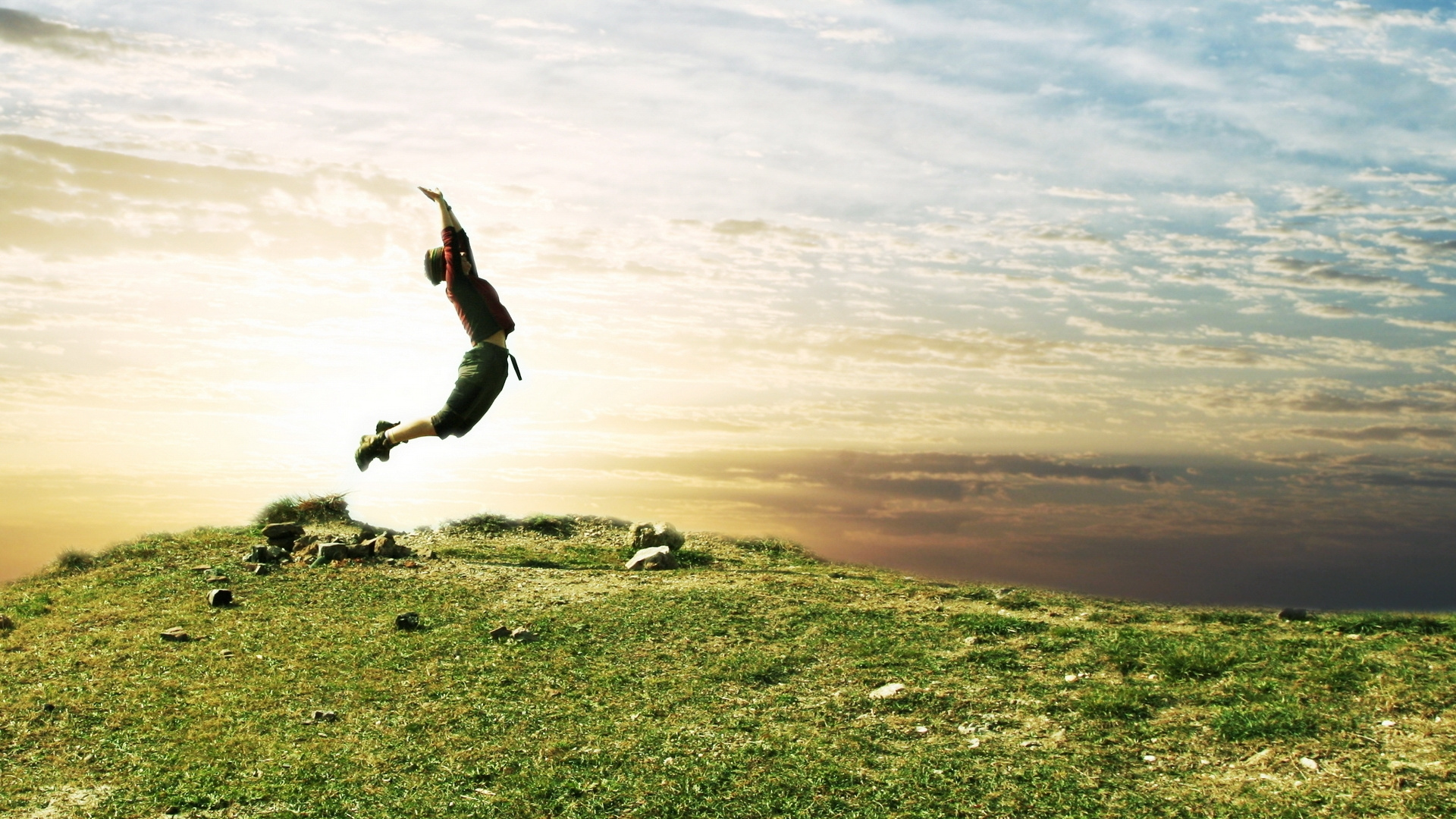 Man in Black Shirt and Black Pants Jumping on Green Grass Field During Daytime. Wallpaper in 1920x1080 Resolution