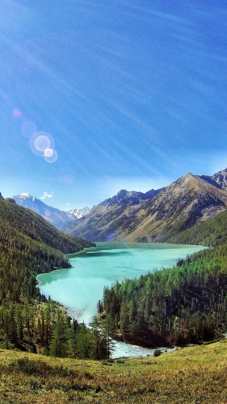 Lago Verde en Medio de Las Montañas Durante el Día. Wallpaper in 750x1334 Resolution