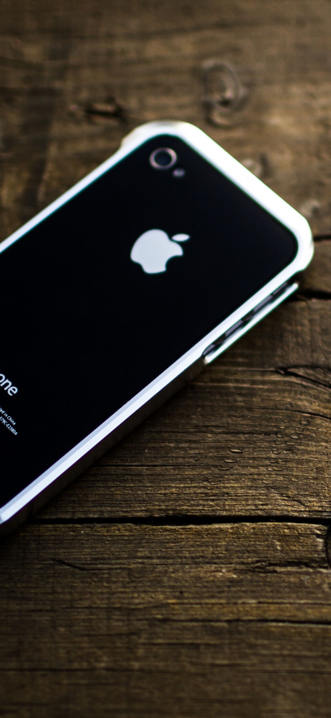 Iphone 4 Negro Sobre Mesa de Madera Marrón. Wallpaper in 1125x2436 Resolution