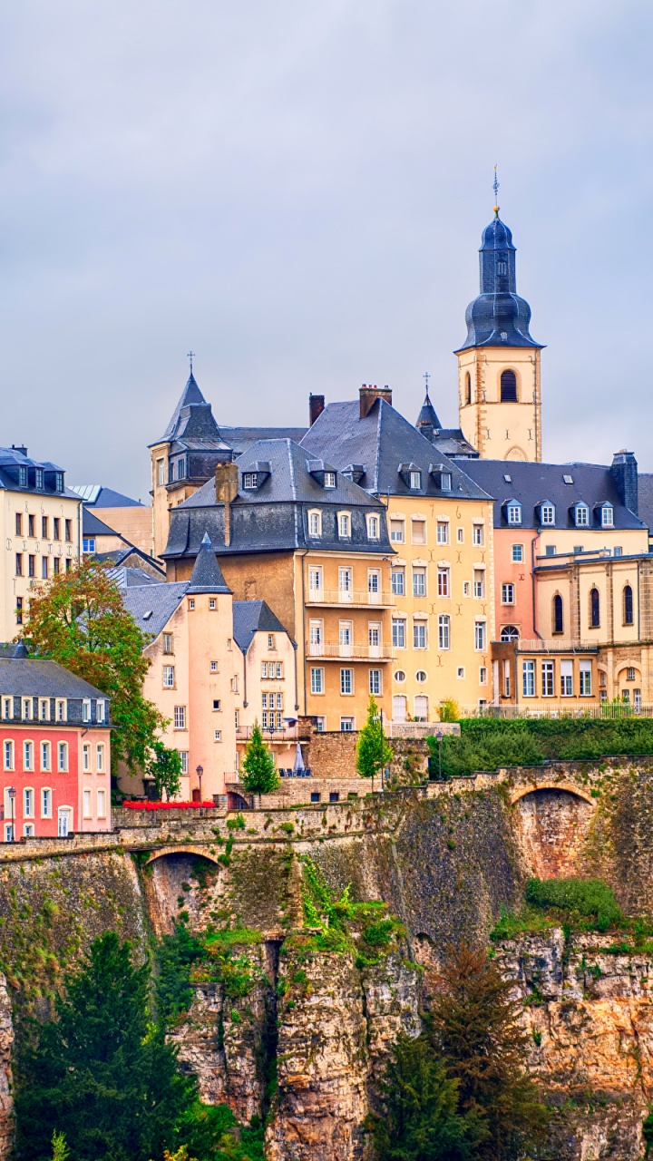 Weißes Und Braunes Betongebäude Auf Einem Hügel. Wallpaper in 720x1280 Resolution