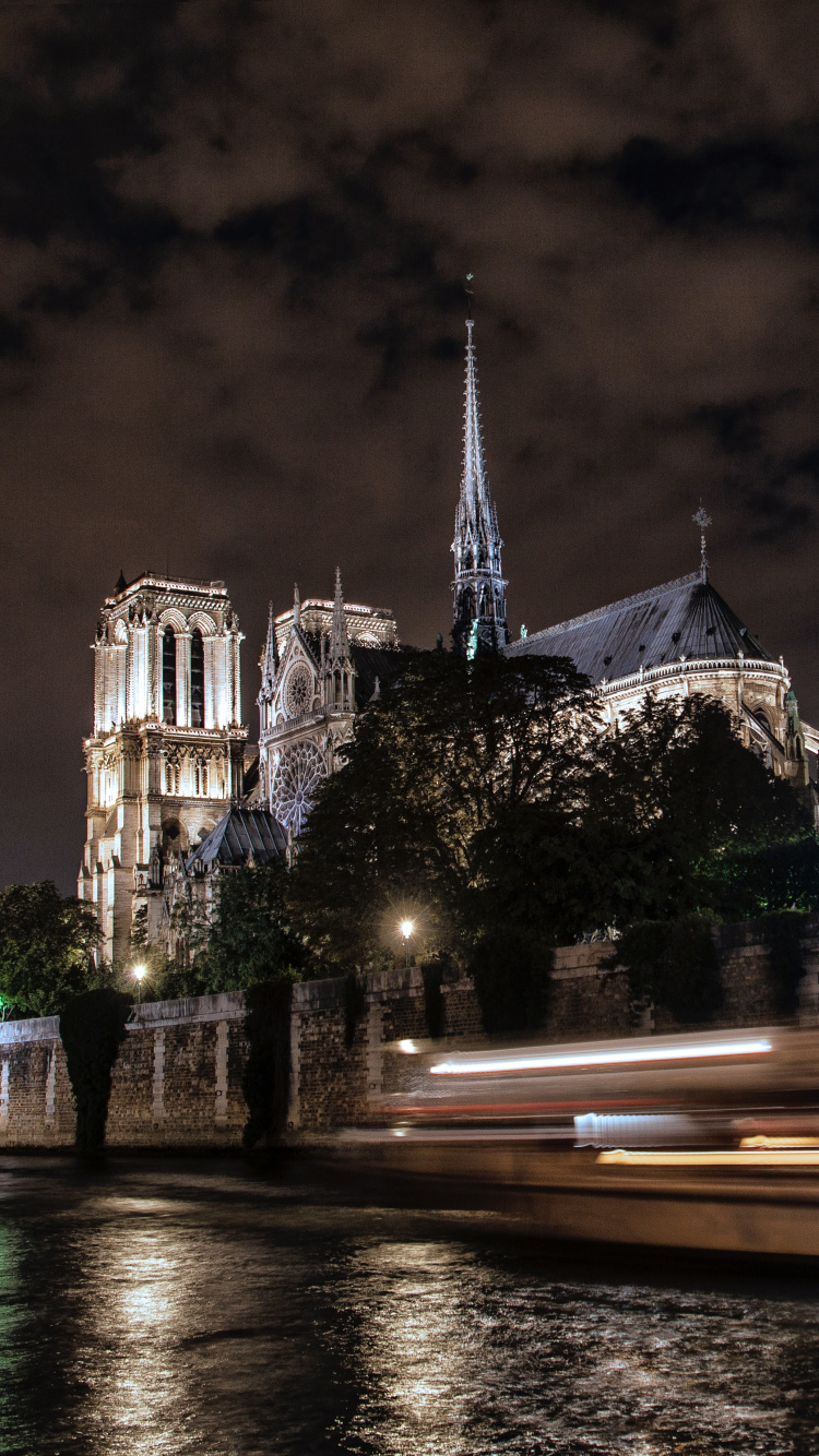 Bâtiment en Béton Blanc et Marron Près D'un Plan D'eau Pendant la Nuit. Wallpaper in 750x1334 Resolution