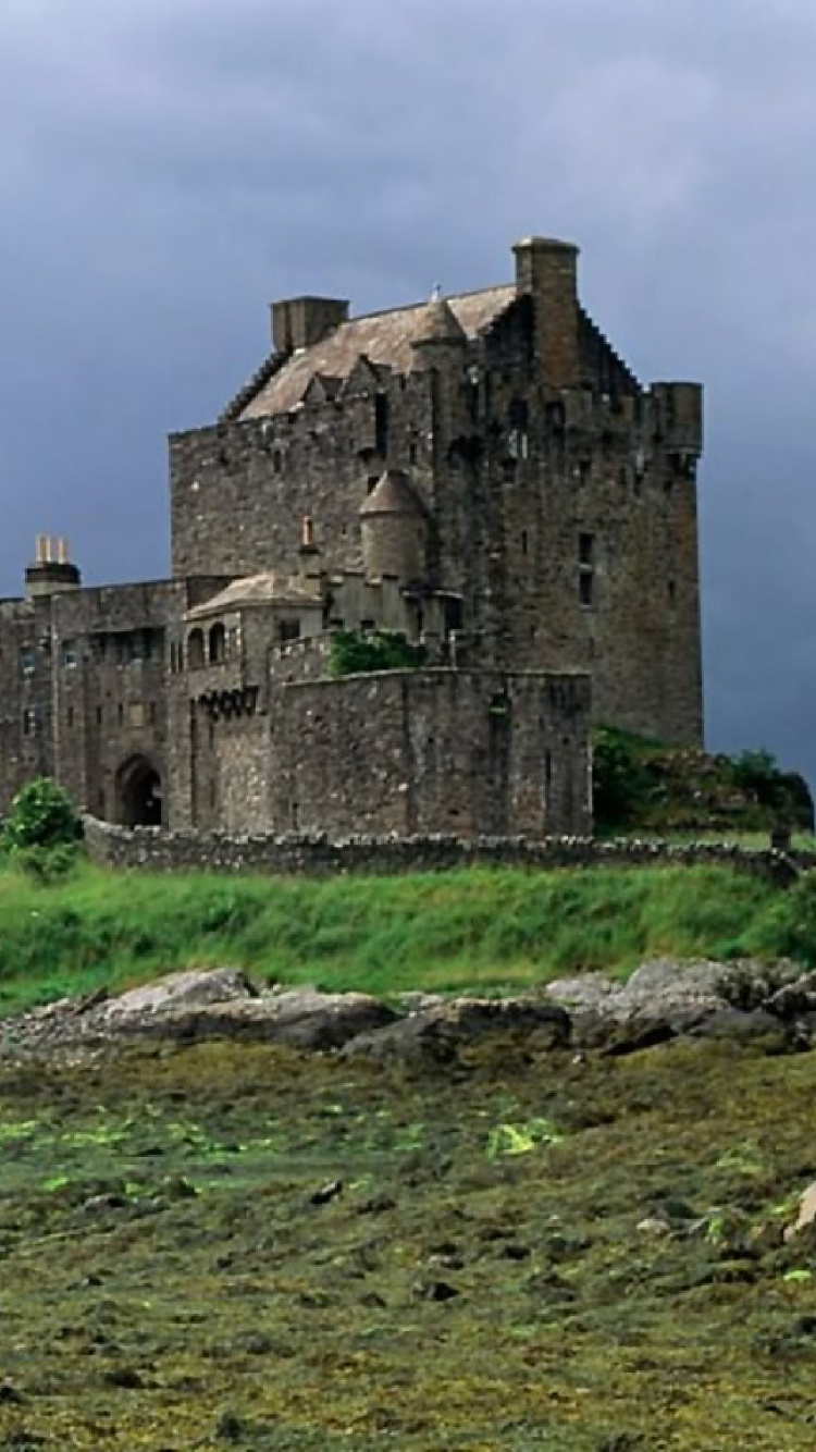 Braunes Betongebäude Auf Grüner Wiese Unter Blauem Himmel Tagsüber During. Wallpaper in 750x1334 Resolution