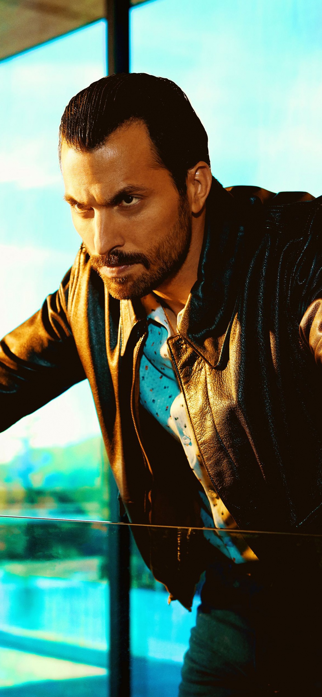 L'homme en Blouson de Cuir Noir Debout à Côté de la Fenêtre en Verre. Wallpaper in 1125x2436 Resolution