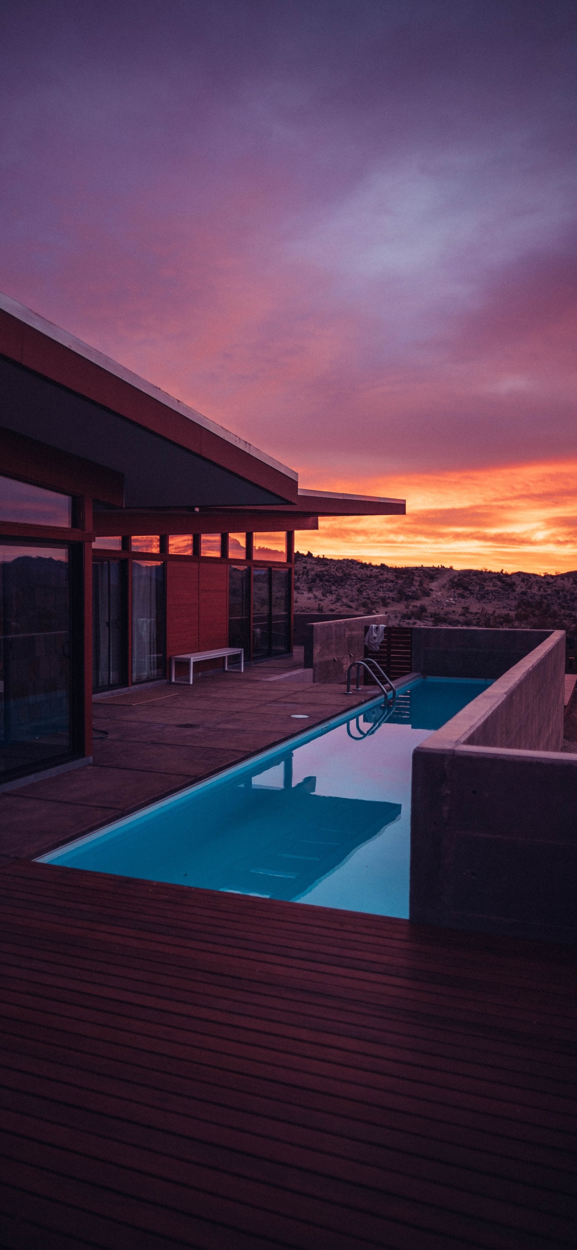 Swimming Pool Near Brown Wooden House During Sunset. Wallpaper in 1125x2436 Resolution